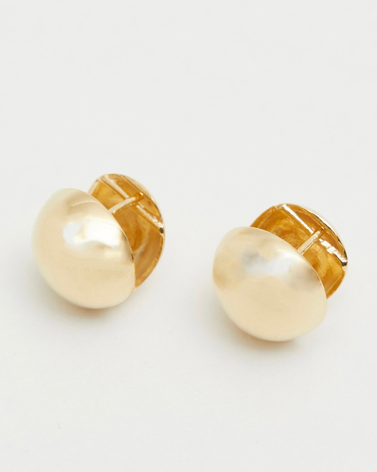 gold dome stud earrings flat lay polished reflective gold minimal jewelry