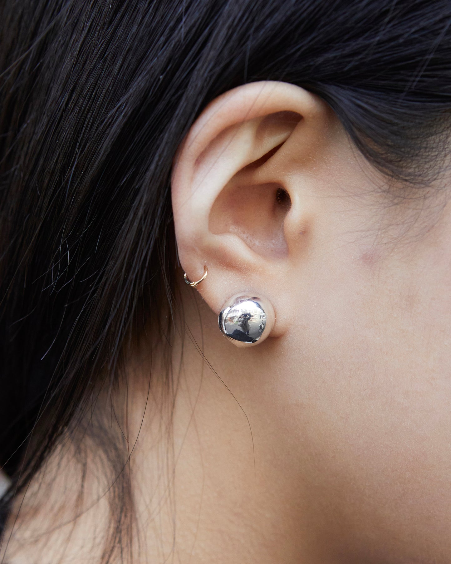 close up silver dome stud earrings reflective surface bold minimal jewelry