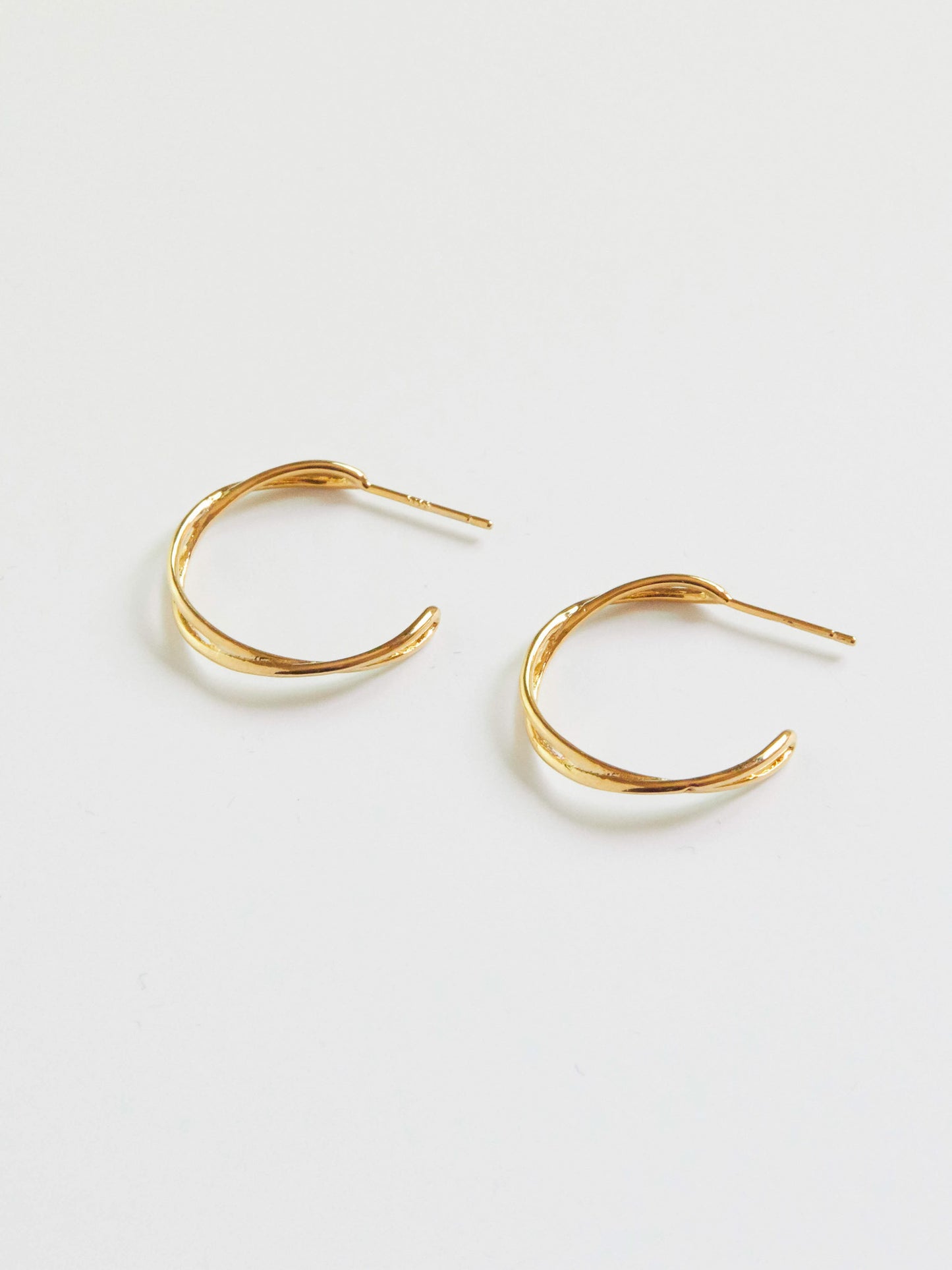 Gold hoop earrings on a light gray background