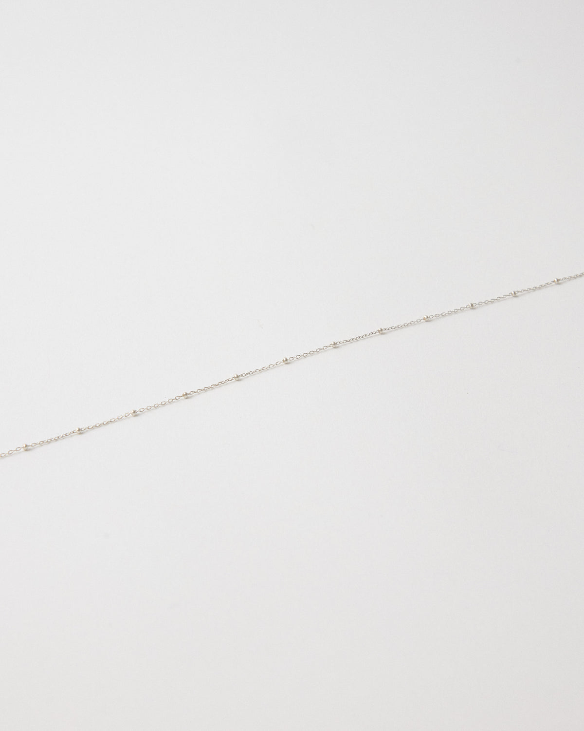 Close-up of a fine silver chain set with tiny silver balls – HANNA543 N1057 starlit dot chain