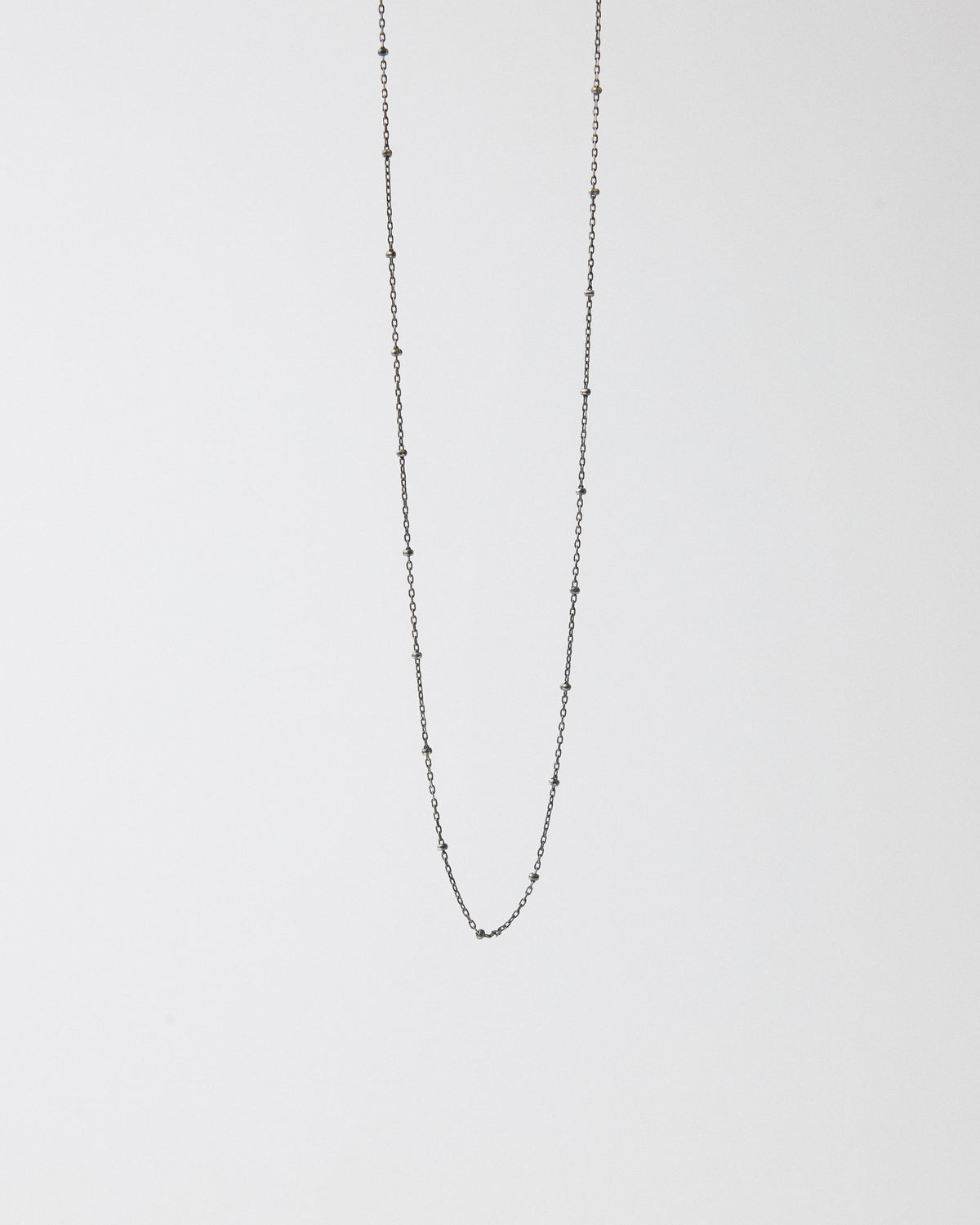 Antique silver ball station chain necklace hanging on a light gray background – HANNA543 N1057 starlit dot chain
