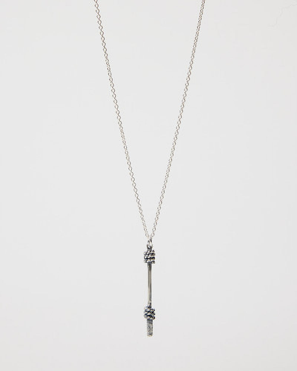 Silver necklace with a unique pendant on a light gray background