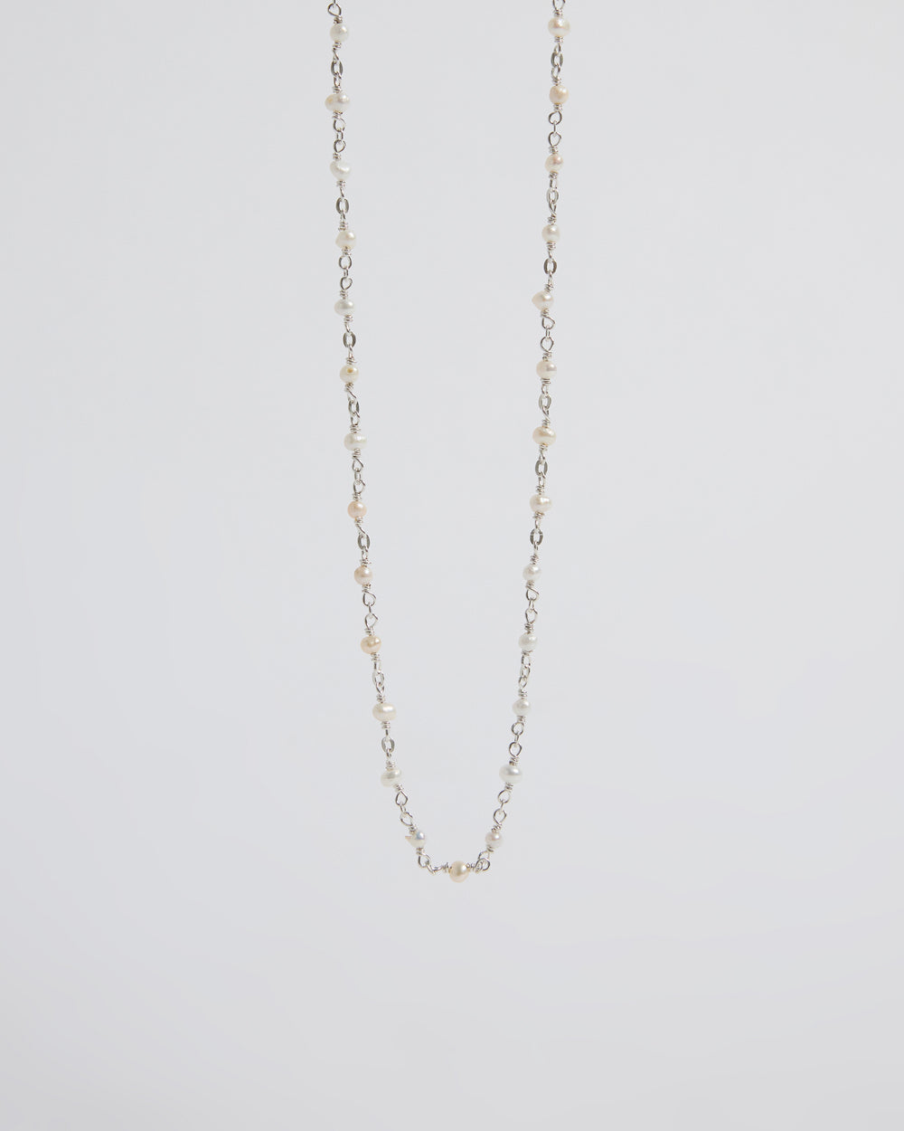 a super delicate pearl necklace that almost disappears into the skin