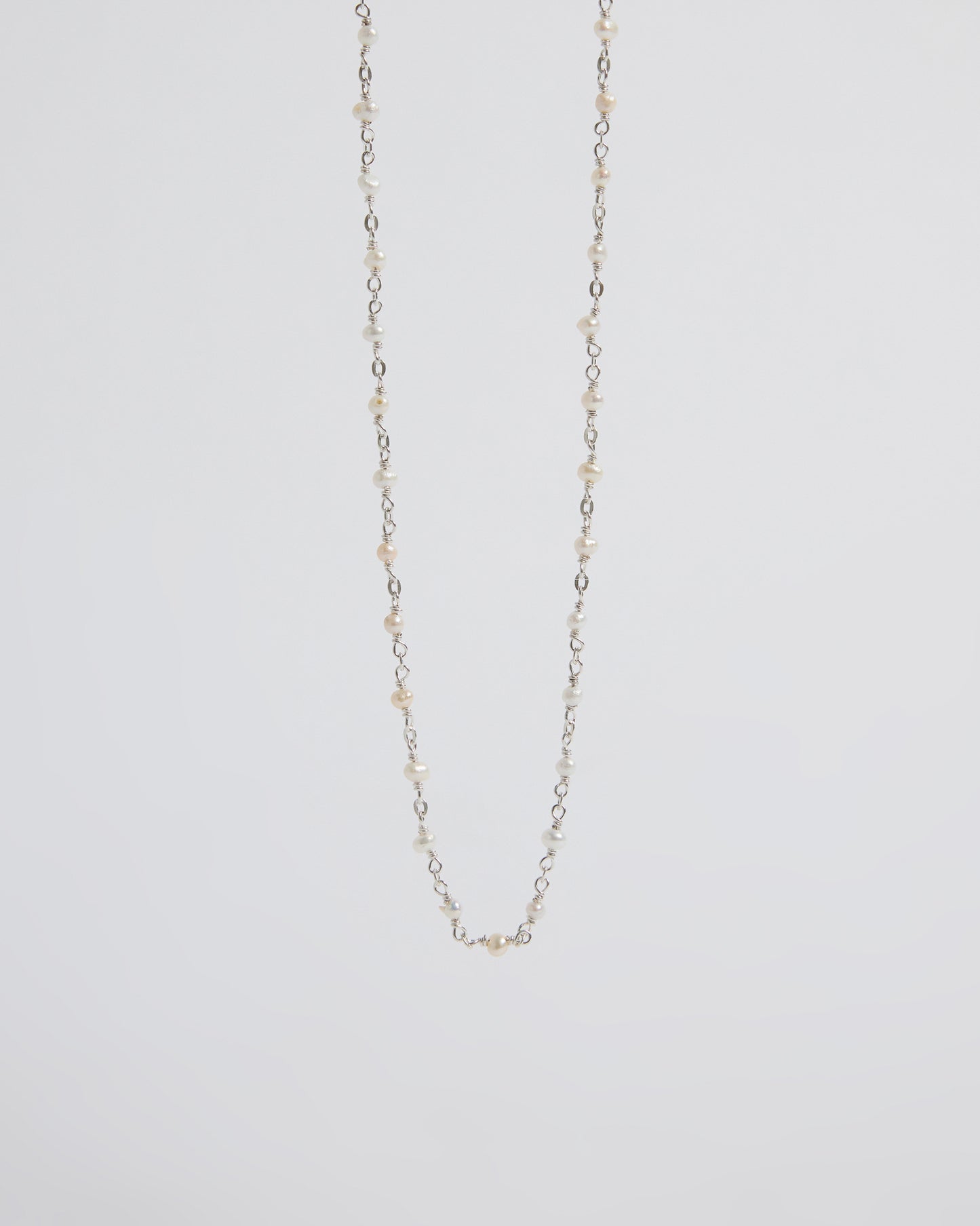 a super delicate pearl necklace that almost disappears into the skin