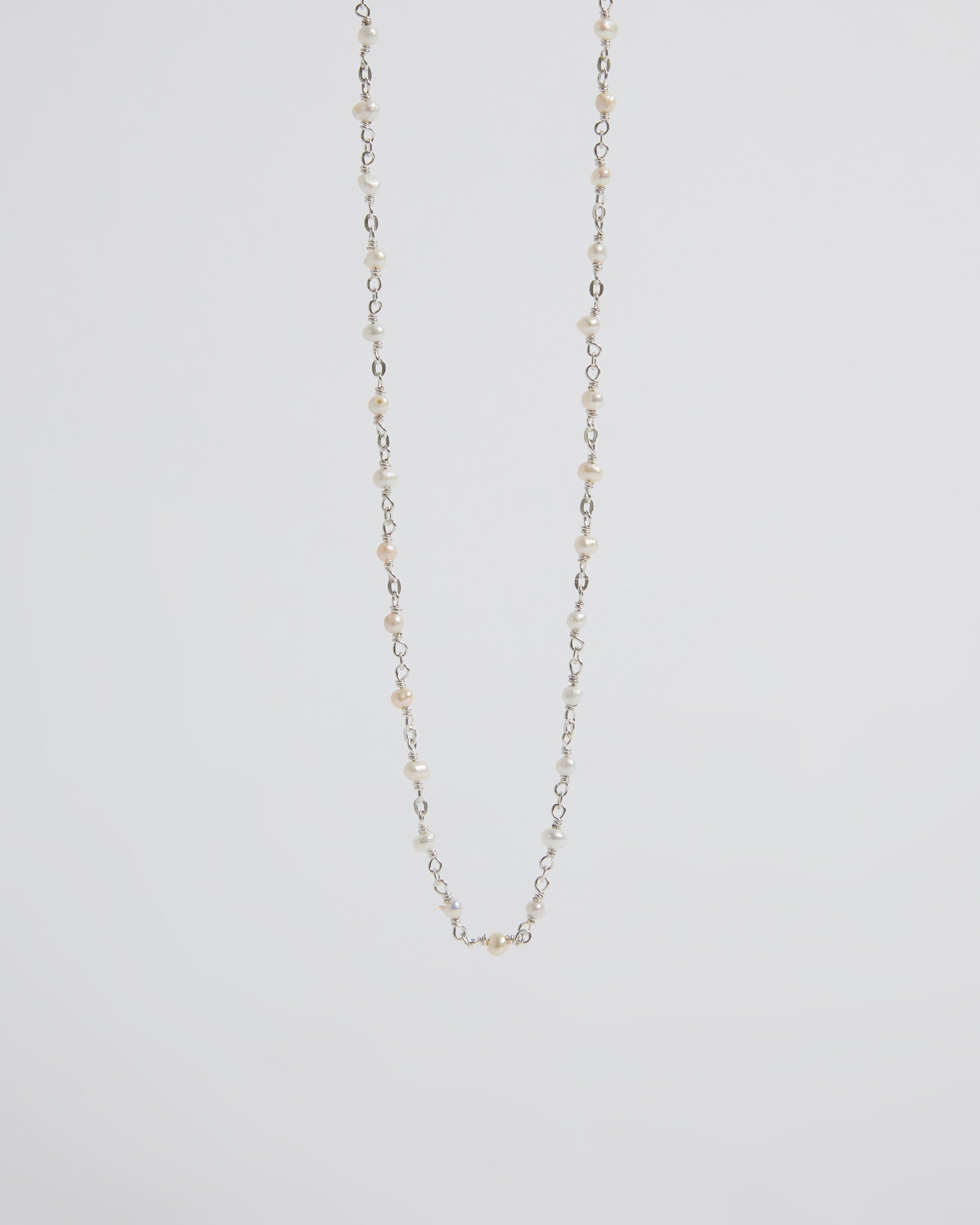 a super delicate pearl necklace that almost disappears into the skin