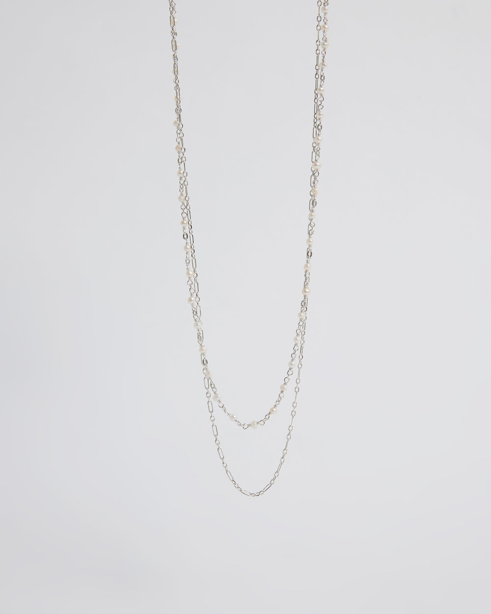Silver chain necklace on a light gray background