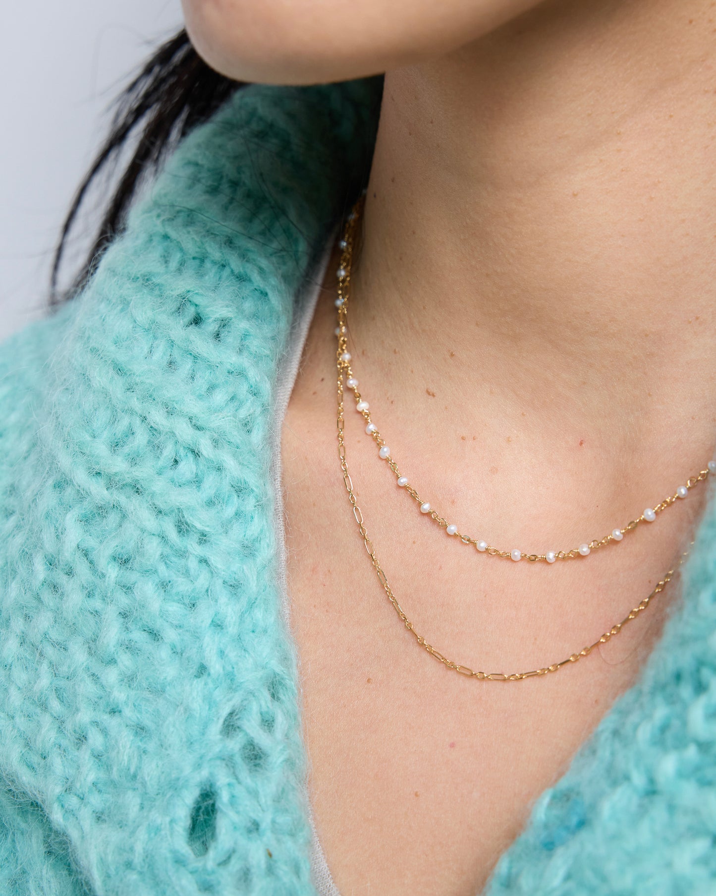 front view of a layered necklace combining pearls and a simple gold chain for a balanced look