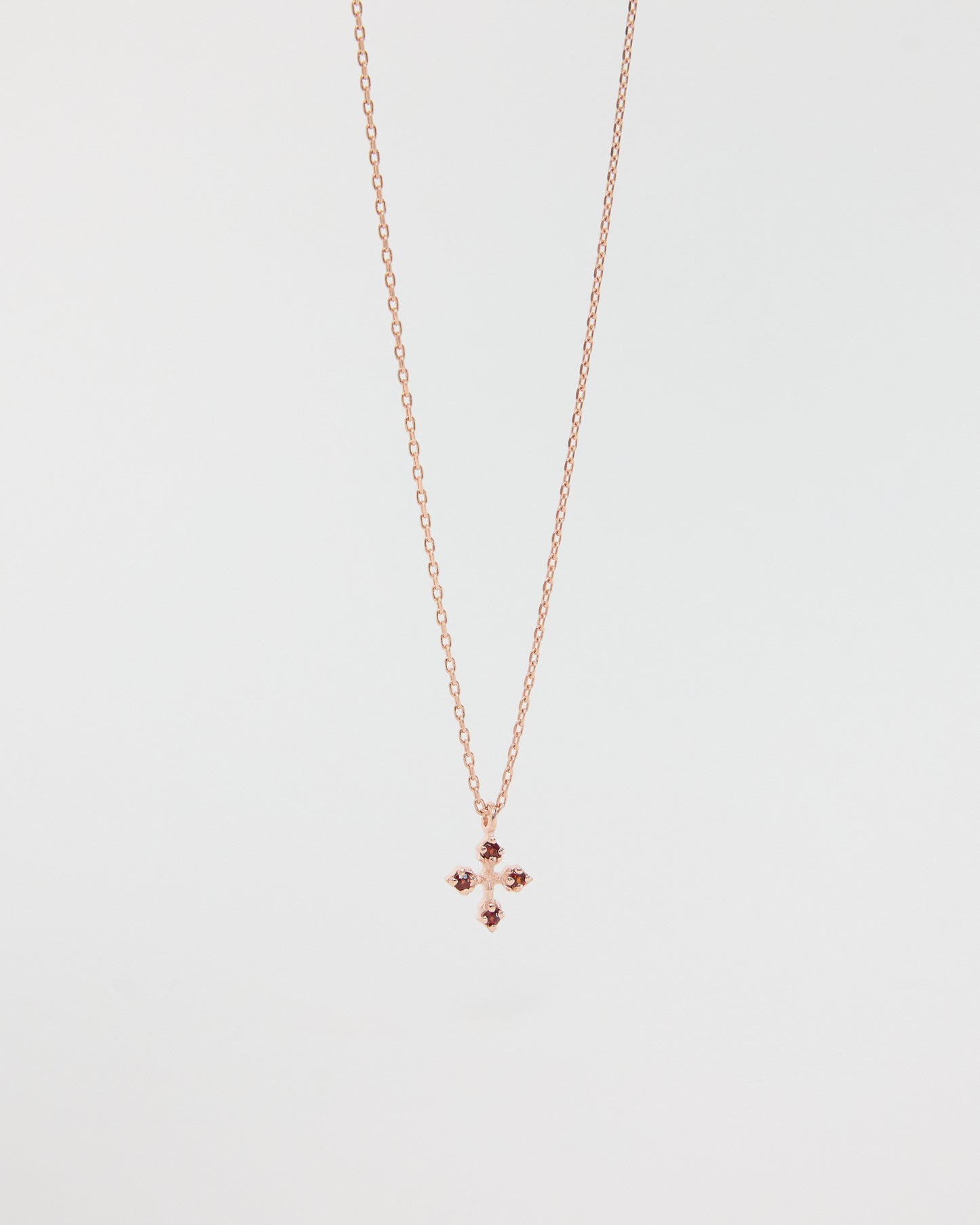 Rose gold necklace with a small pendant on a light gray background