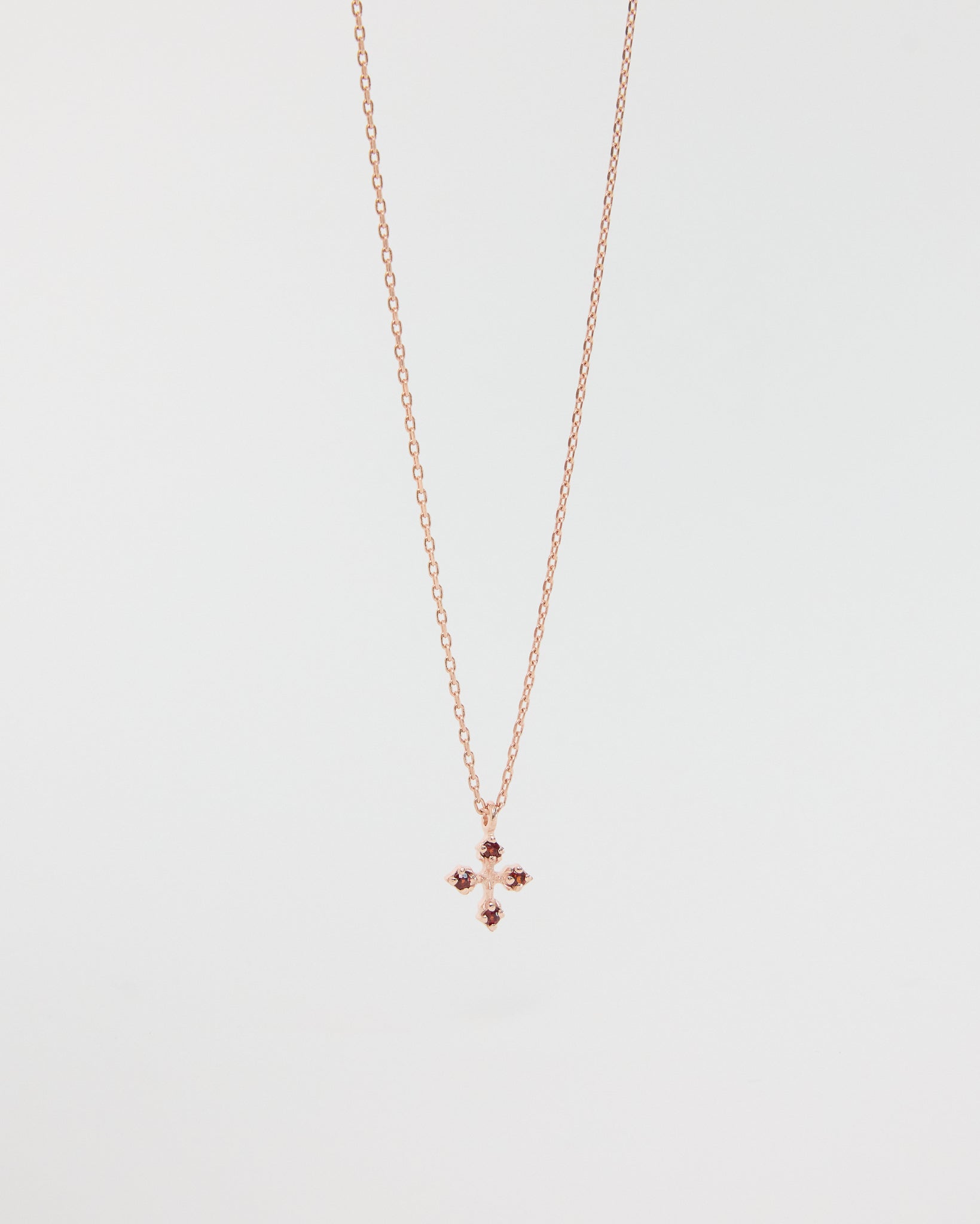 Rose gold necklace with a small pendant on a light gray background