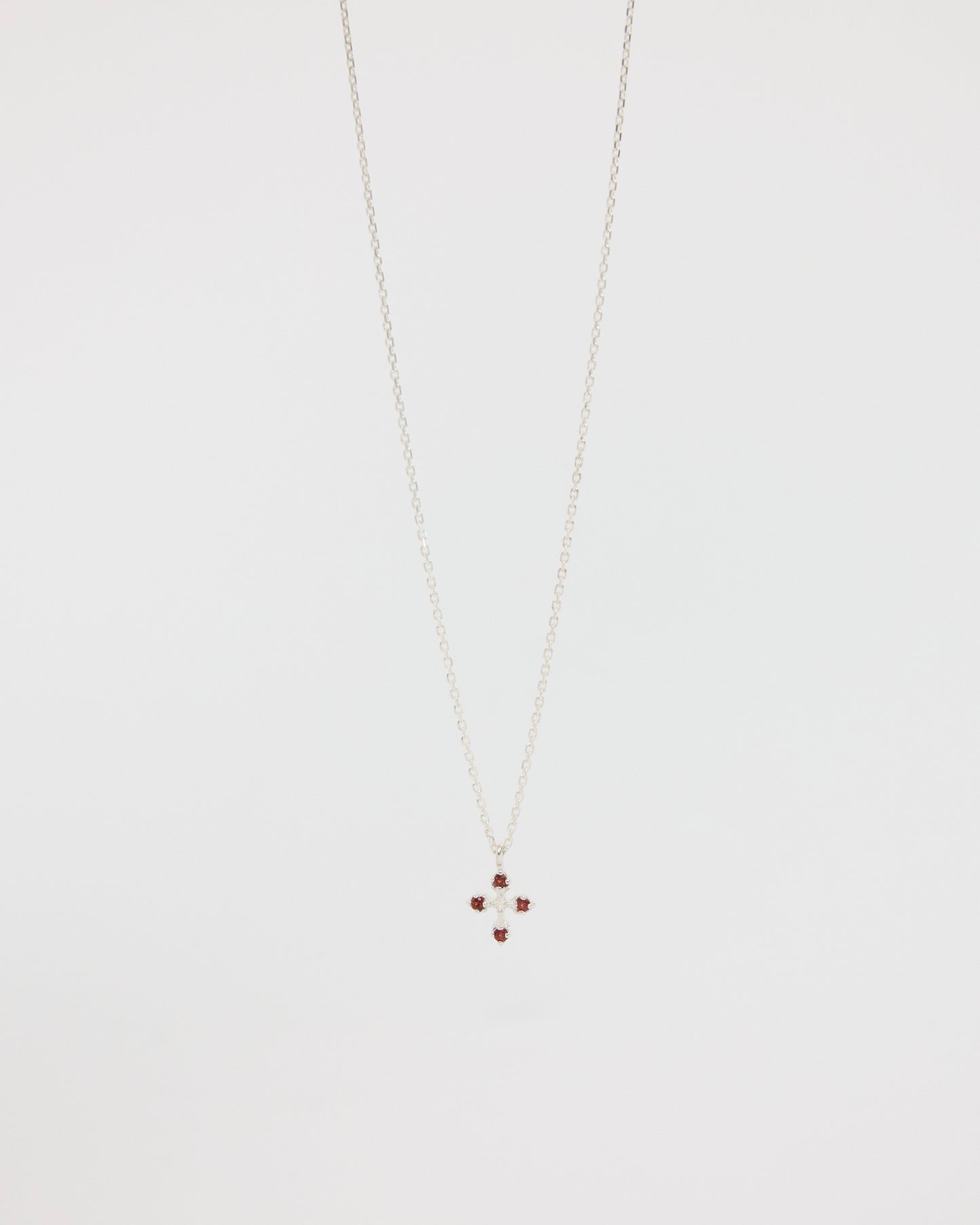 Necklace with a small cross pendant on a light gray background
