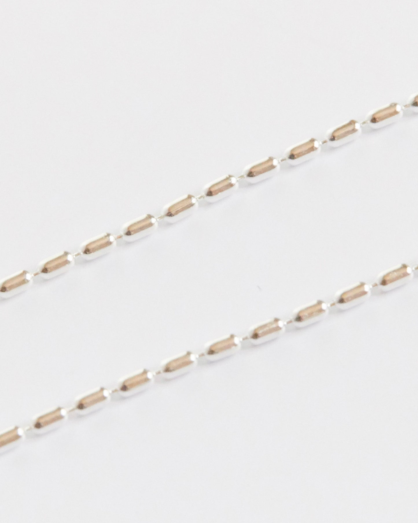 tiny geometric silver links lined up like they had a meeting about symmetry (and actually agreed)