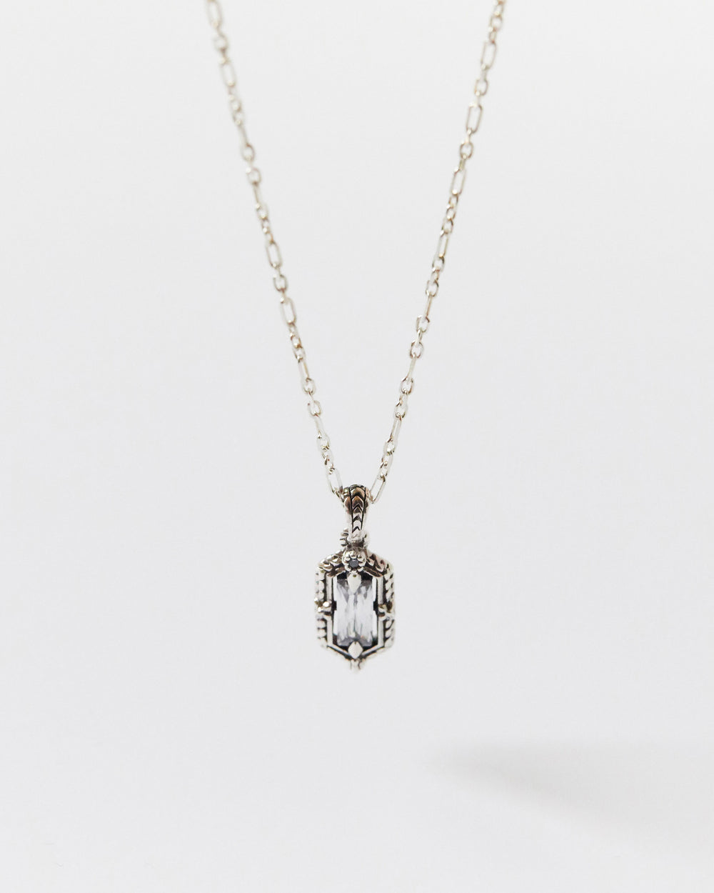 Silver necklace with a rectangular pendant on a white background