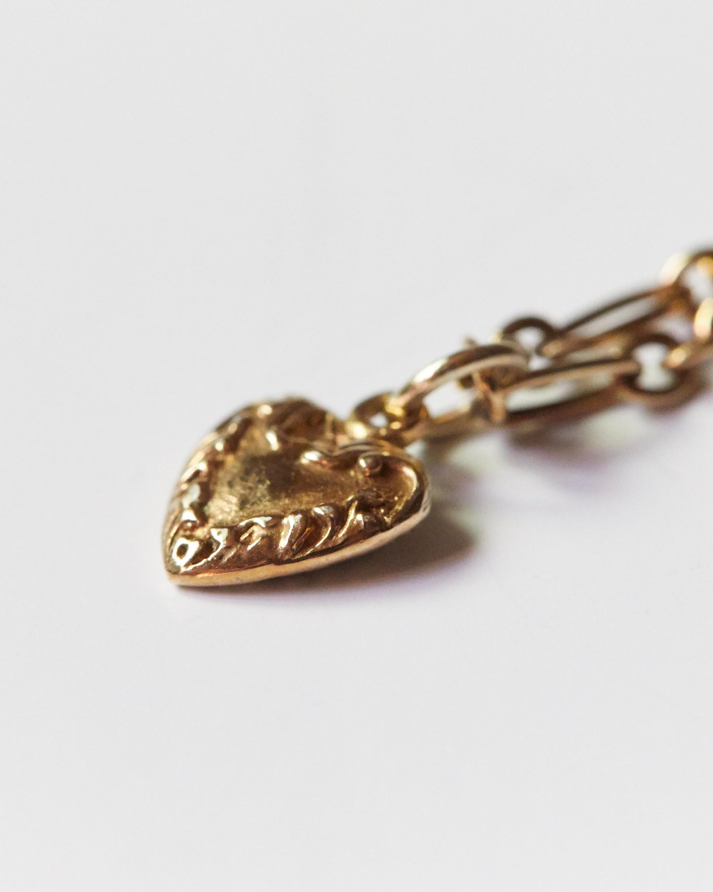 Flatlay of silver heart charm necklace stretched diagonally