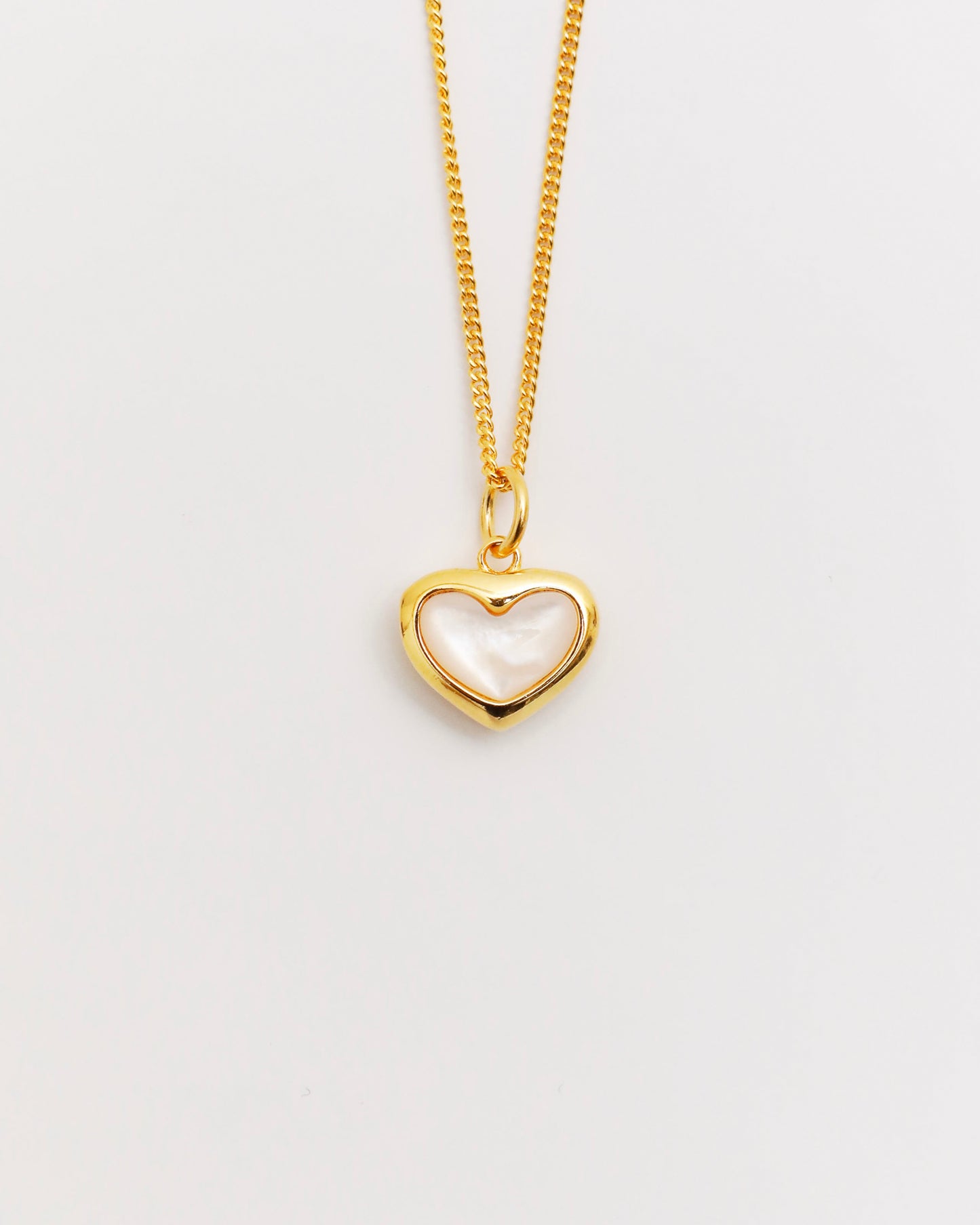 gold heart necklace featuring mother of pearl inlay, delicate chain on white background