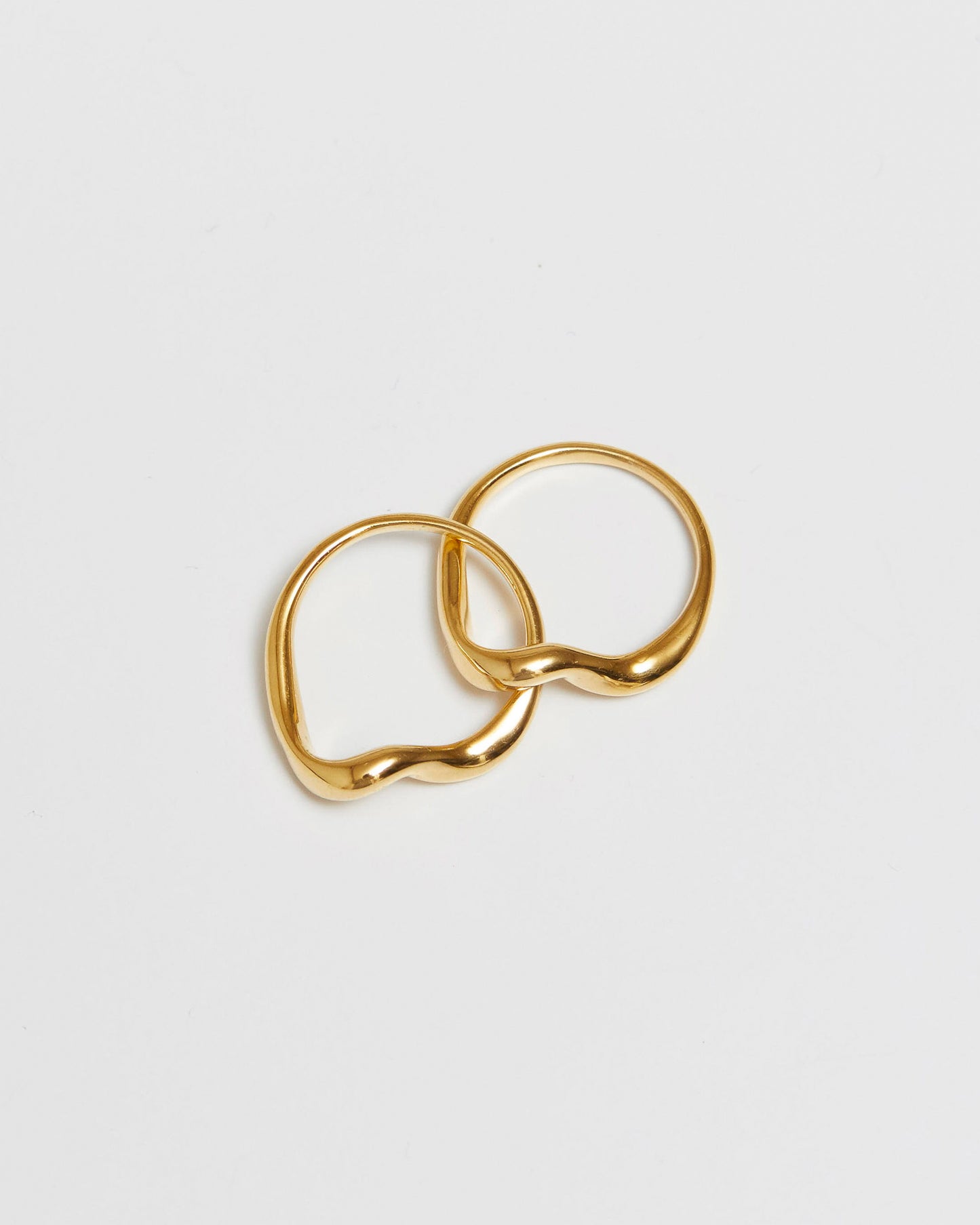 gold rings being held over an open palm, mid-air styling view