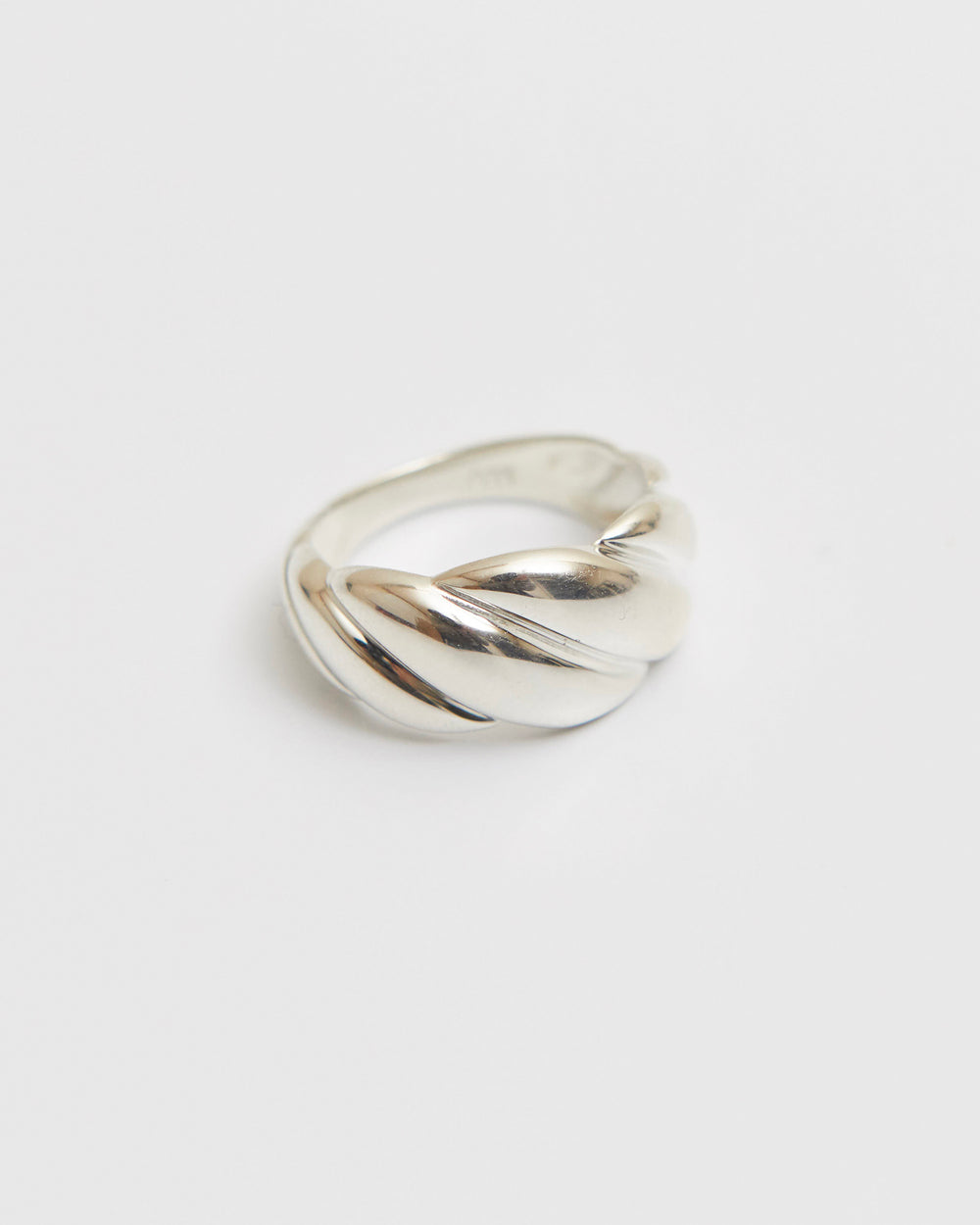 architectural twisted ring with sculpted volume and continuous curved form in polished metal