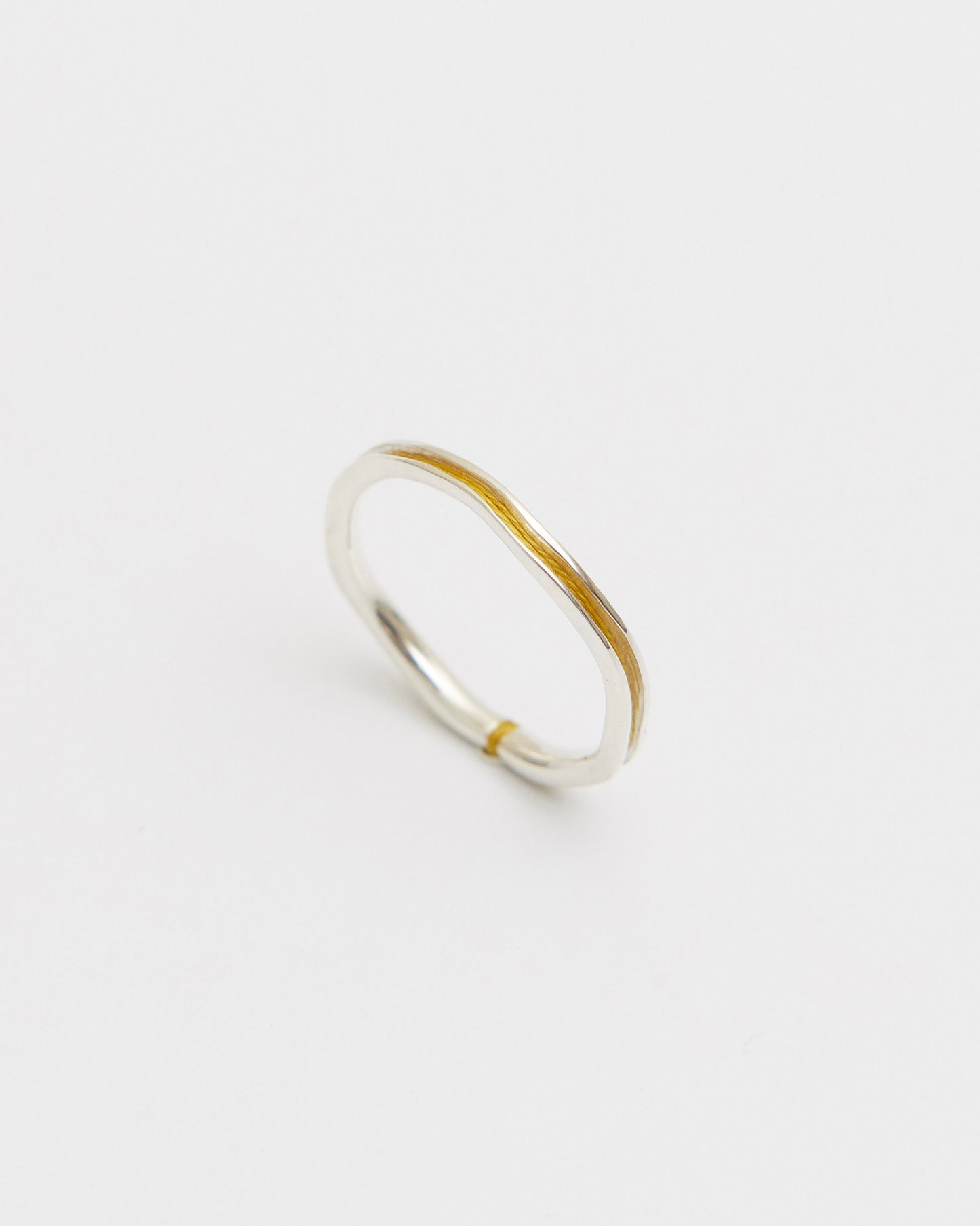 Silver ring with mustard accent on a white background