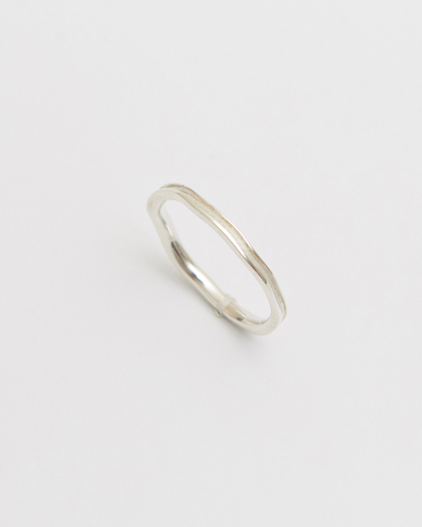 Silver white ring on a light gray background