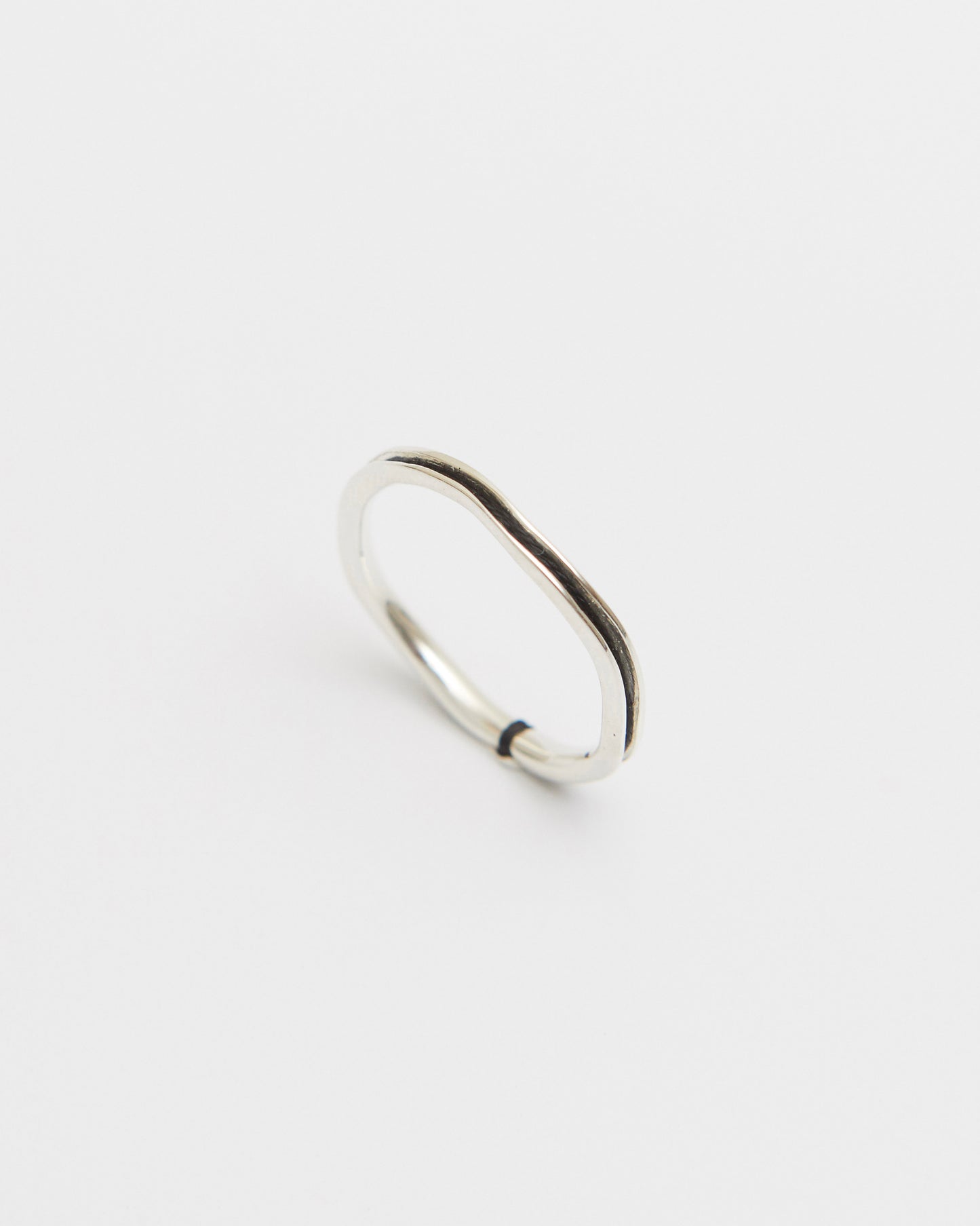 Silver black ring on a light gray background