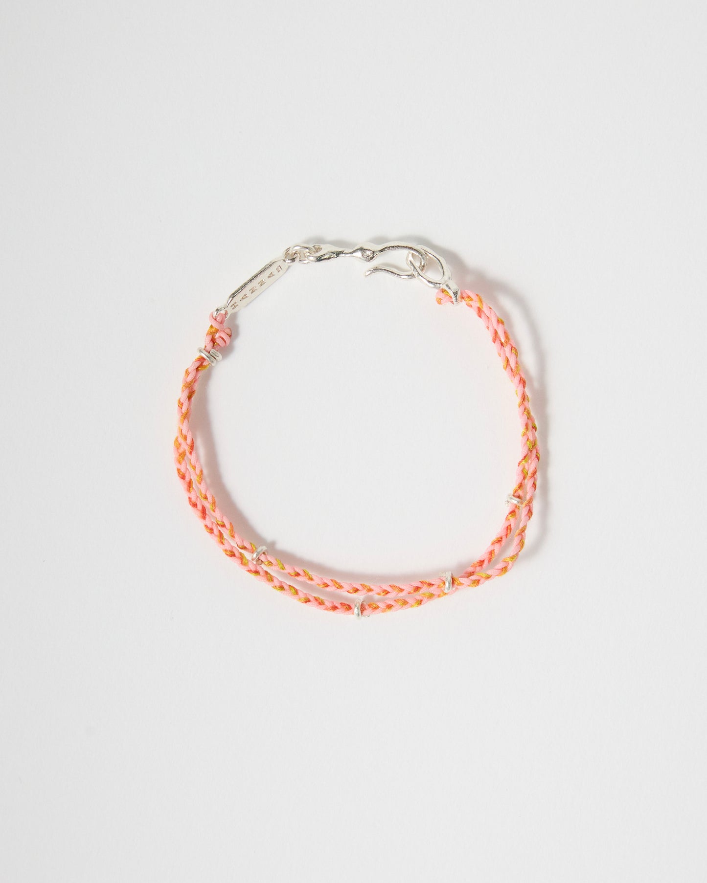 Close-up of handwoven pink bracelet featuring sterling silver details