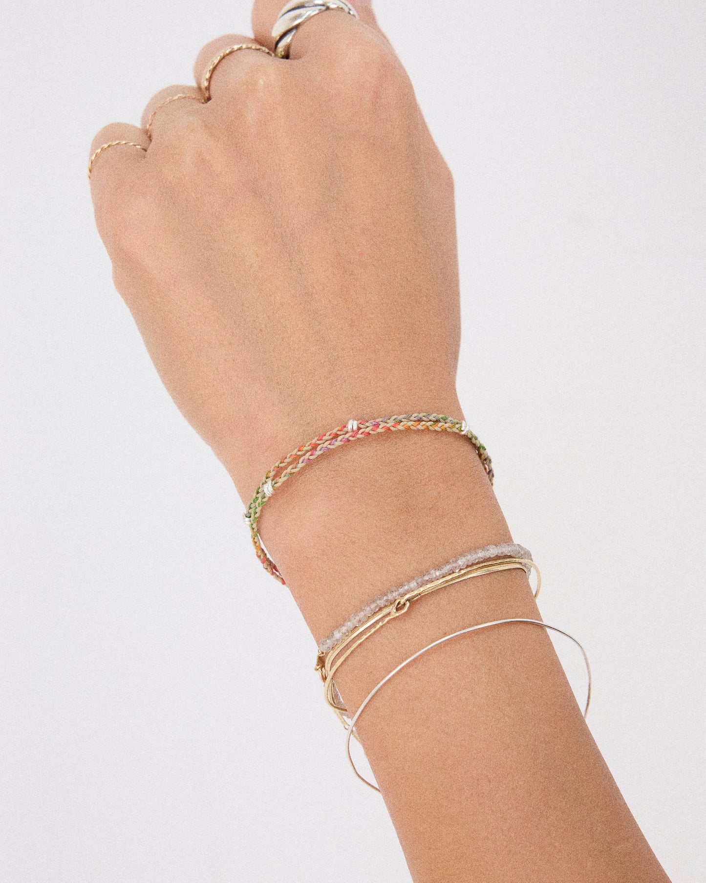 Pastel rainbow bracelet layered with silver bangles for everyday jewelry styling