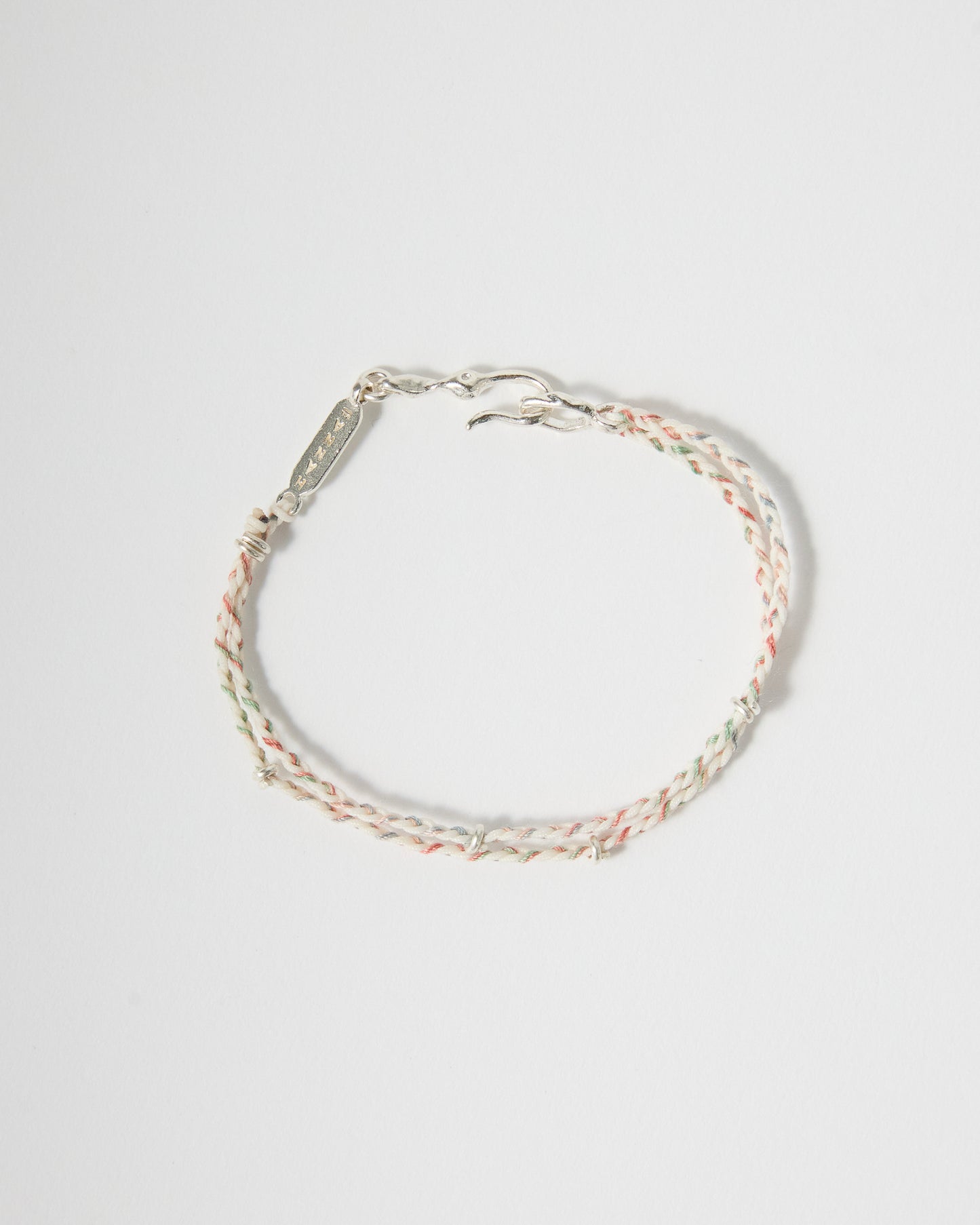 Handmade braided bracelet featuring cream, blush pink, mint, and pale blue threads with sterling silver details