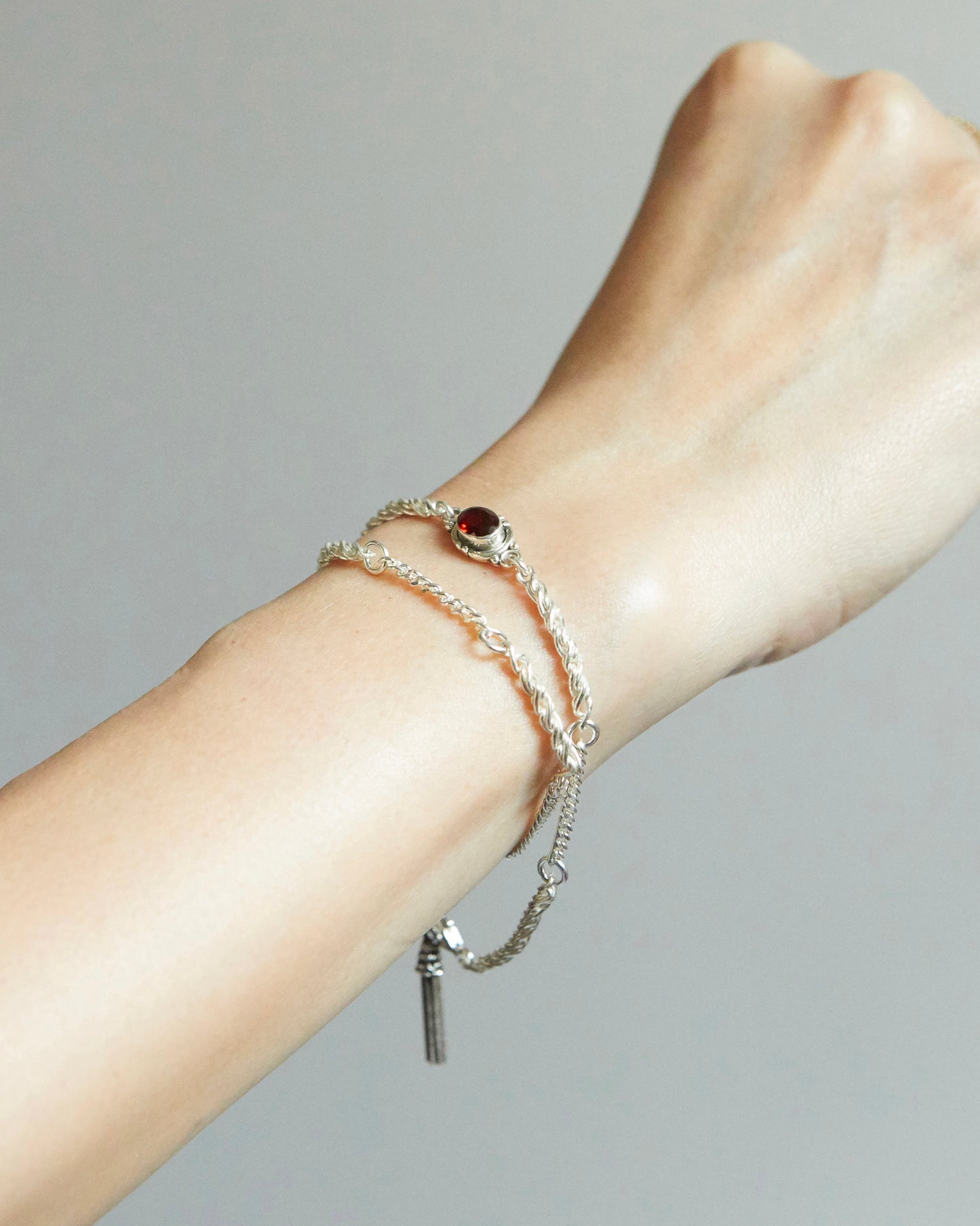 silver bracelet with red gemstone worn on wrist with soft natural light