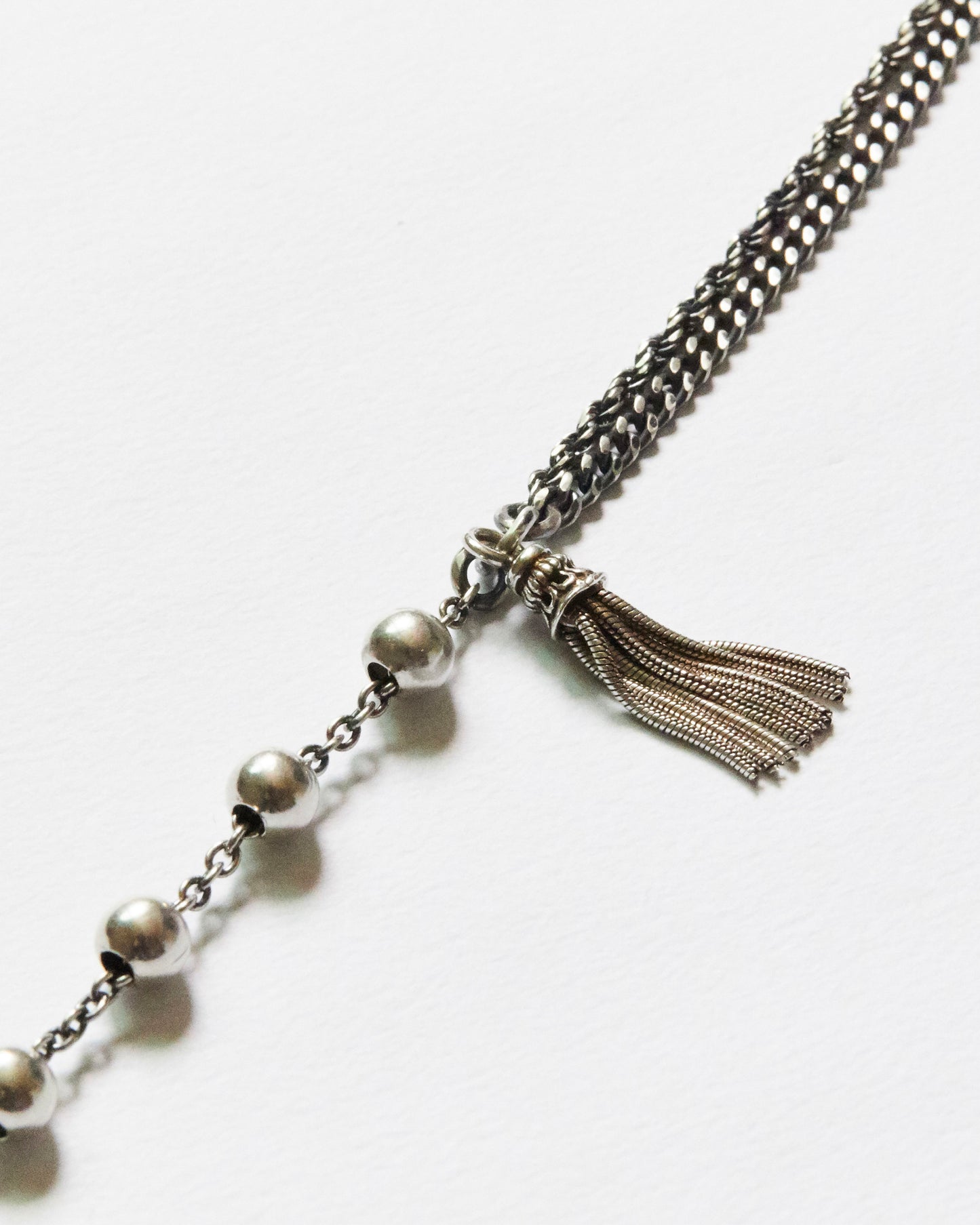 antique silver chain necklace with tassel on a white background