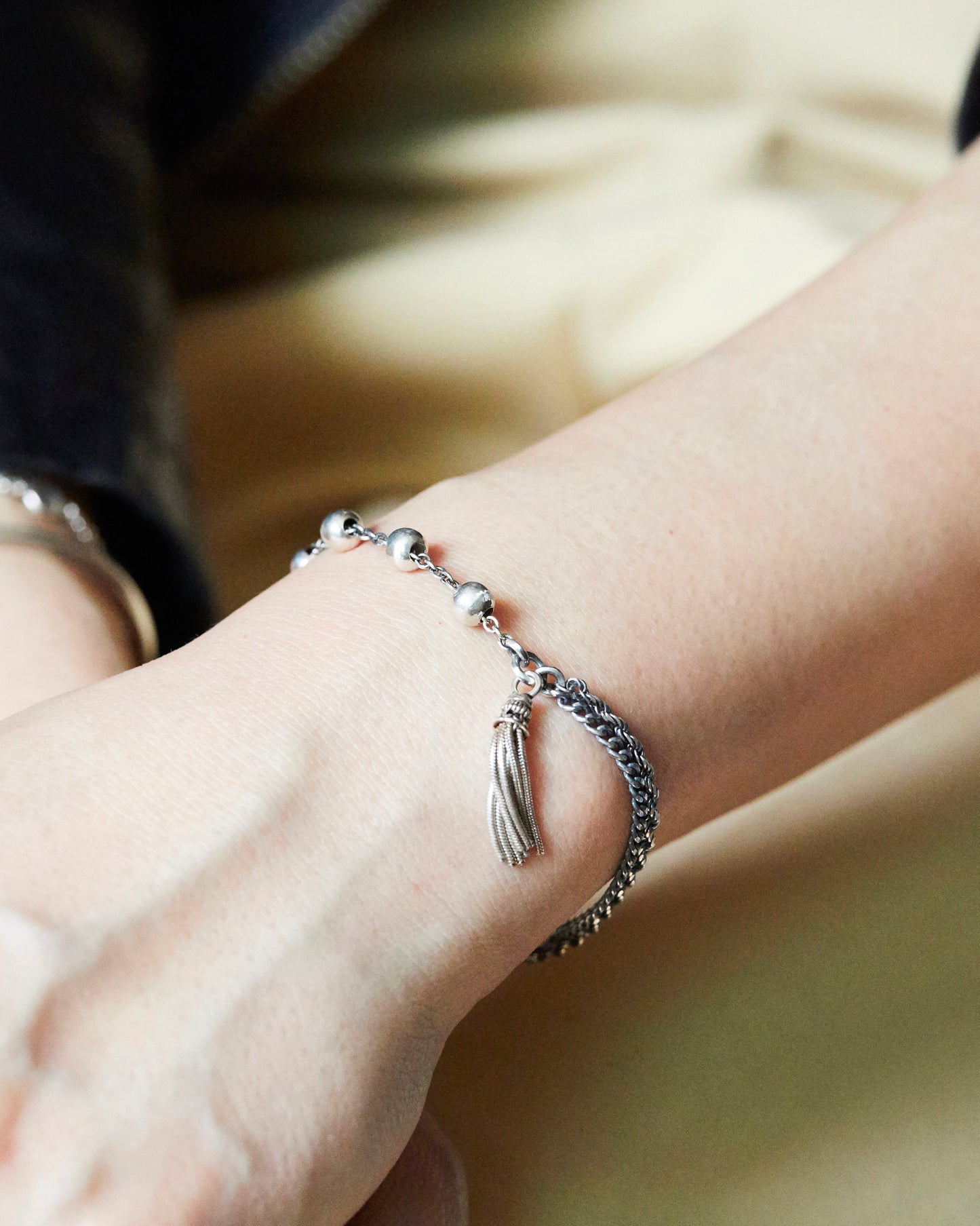 silver bead and tassel bracelet worn with black outfit for modern styling