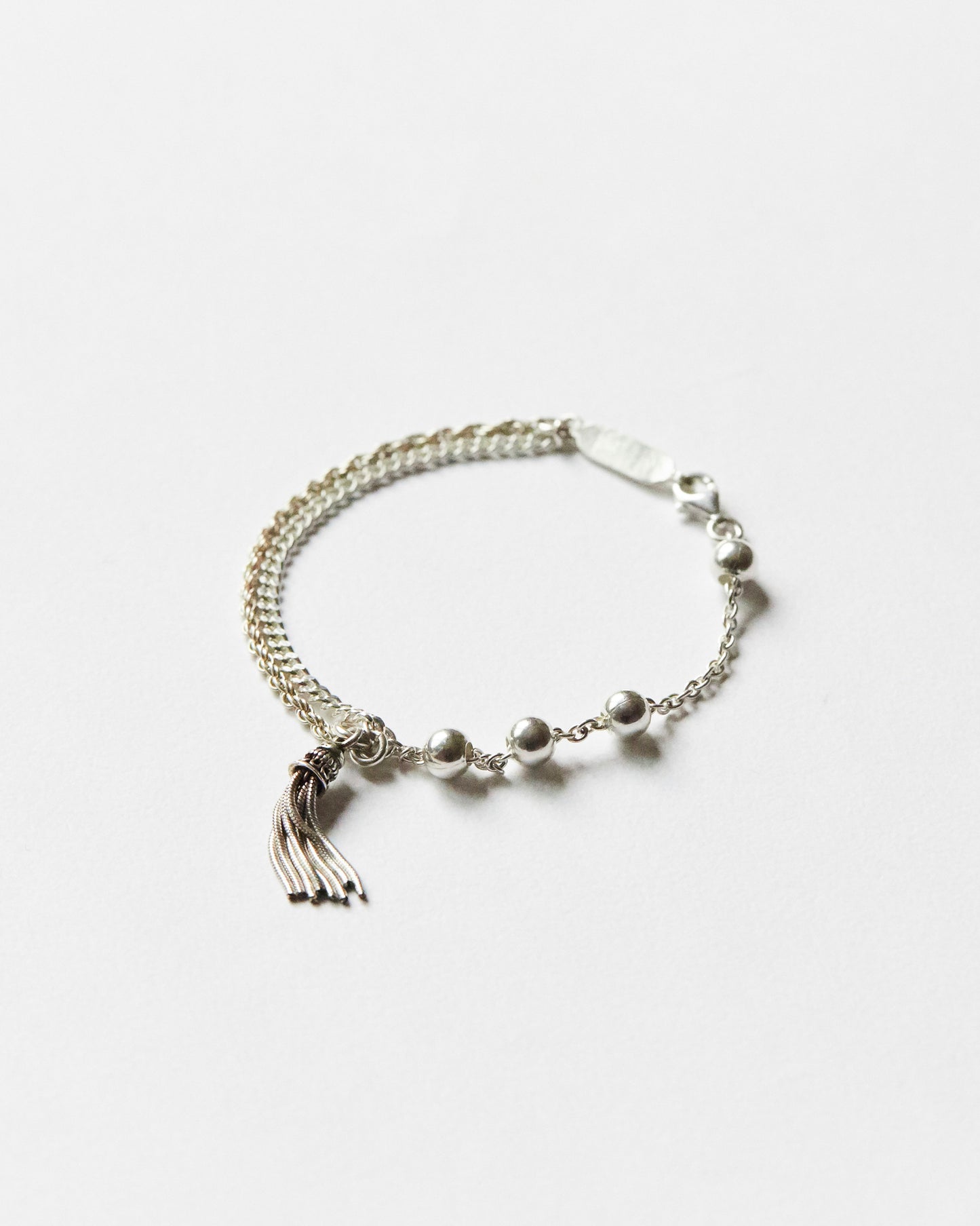 minimal silver bead bracelet with tassel and dual chain texture