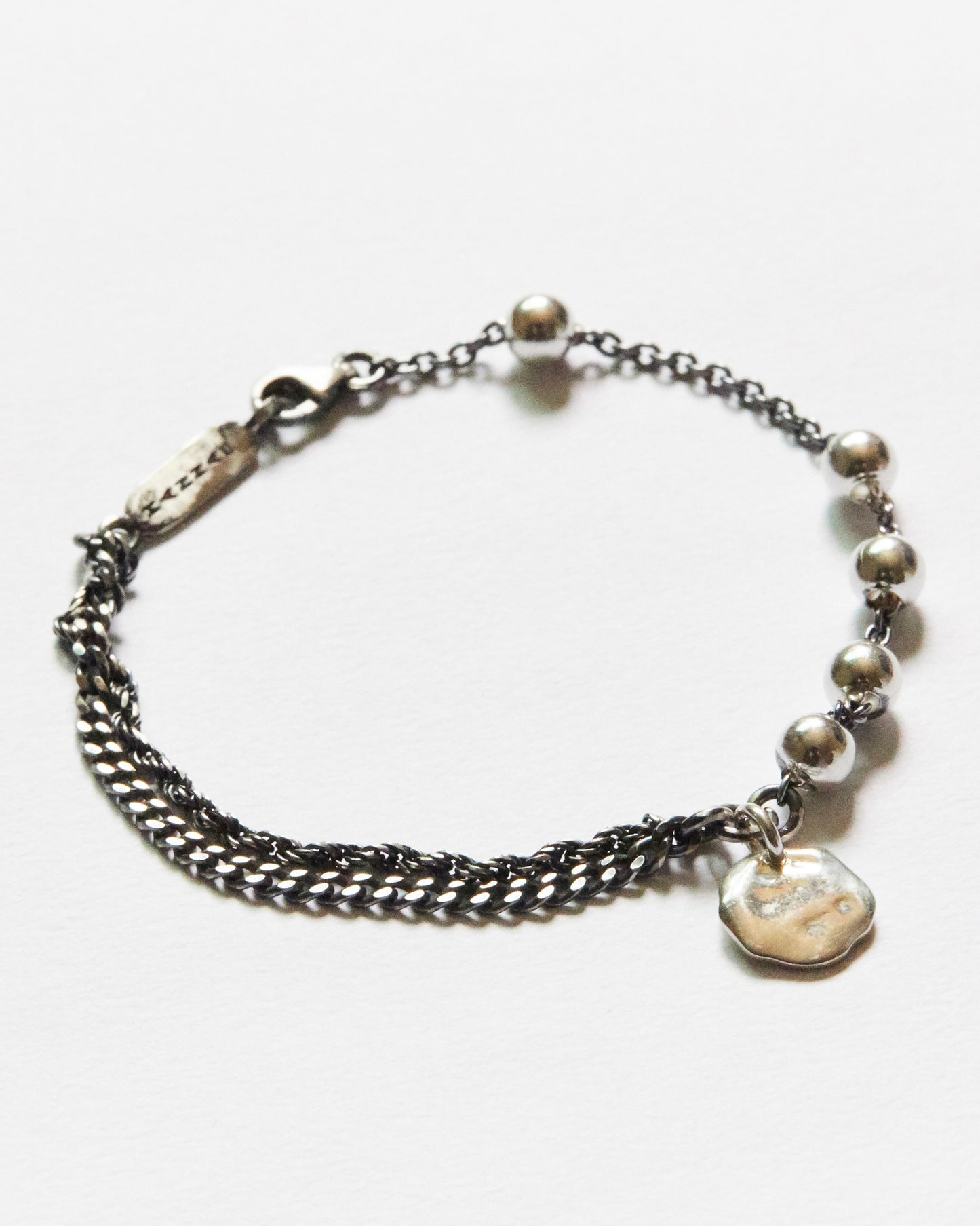 macro detail of silver bead chain and organic charm bracelet premium minimal jewelry texture
