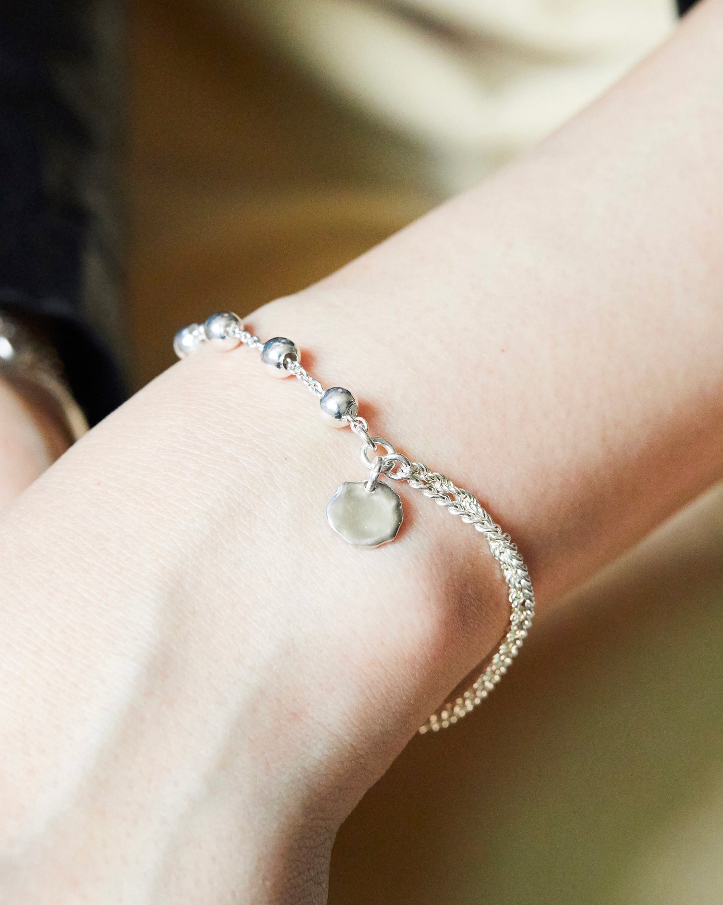 silver chain bracelet with bead and charm worn with leather jacket edgy street style jewelry
