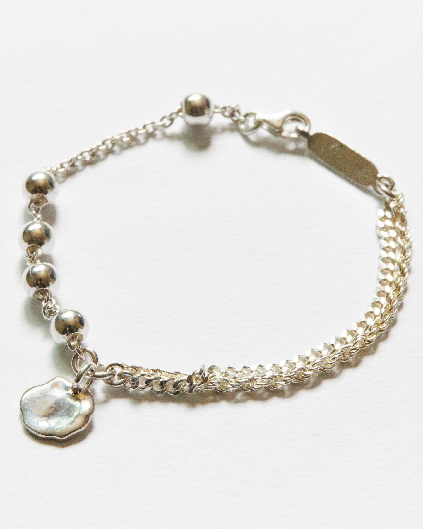 silver bracelet with chain and round beads on a white background