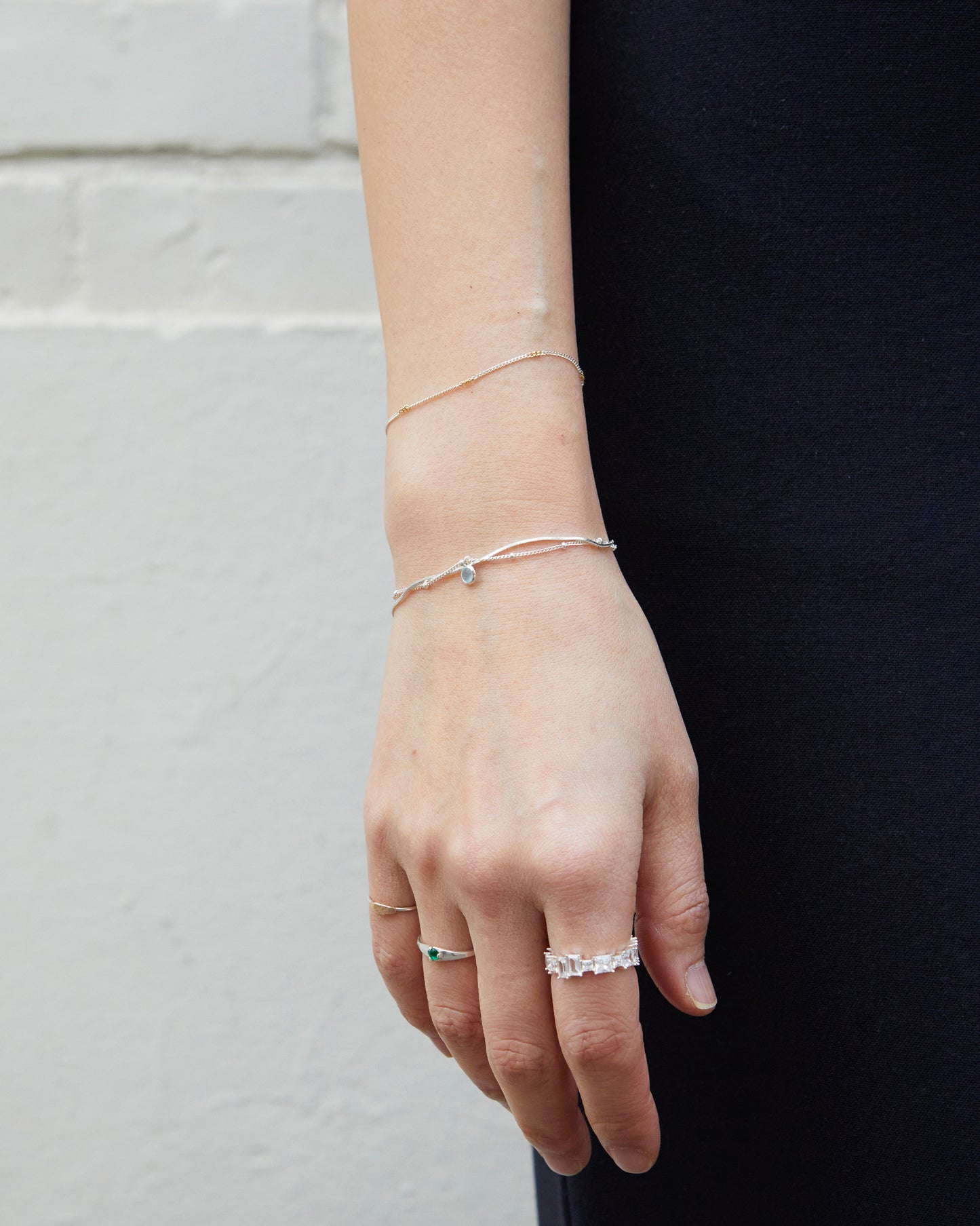 Delicate silver bracelet with blue gemstone styled on wrist