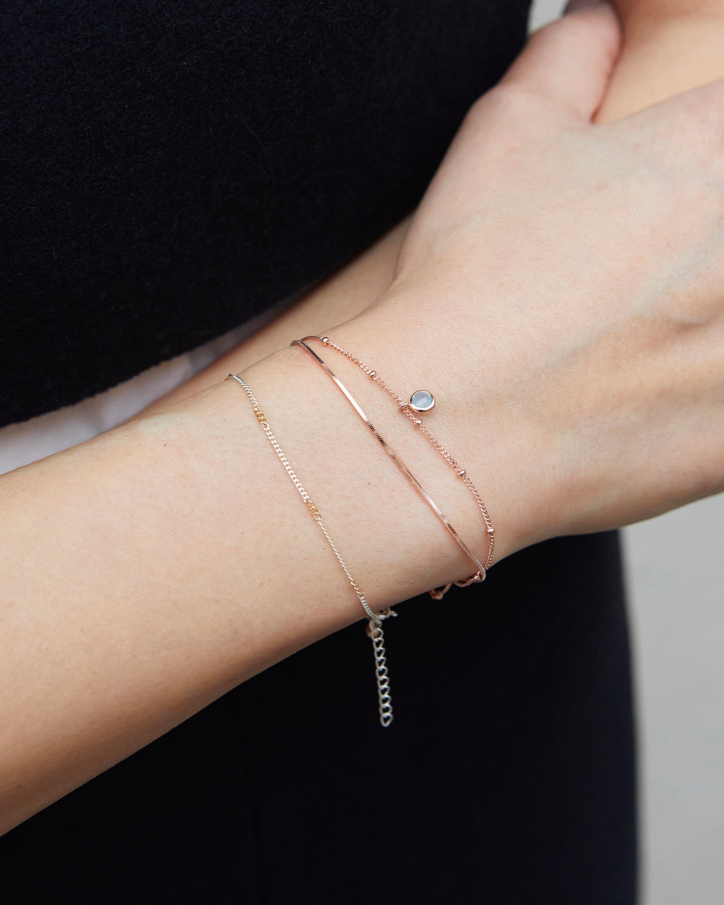 Minimal sterling rose gold bracelet layered with rings for everyday styling