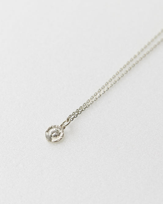 Antique-style coin necklace with portrait engraving, photographed from front