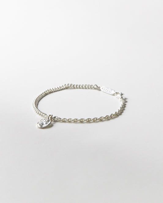 925 silver bracelet with dual chain detail and textured coin pendant on white background