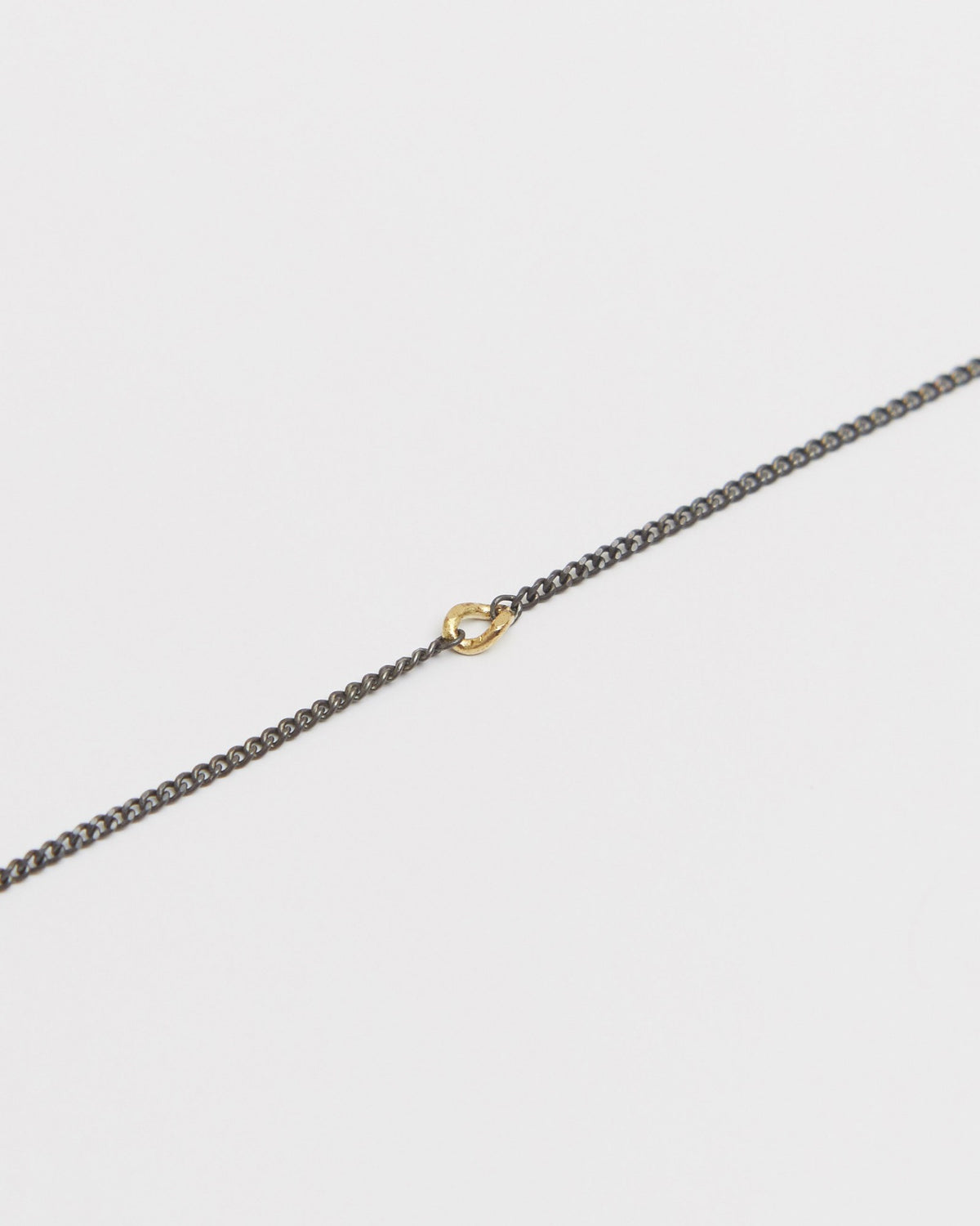 Close-up of the 14K gold detail on an antique silver curb chain – HANNA543 B535 gold note chain