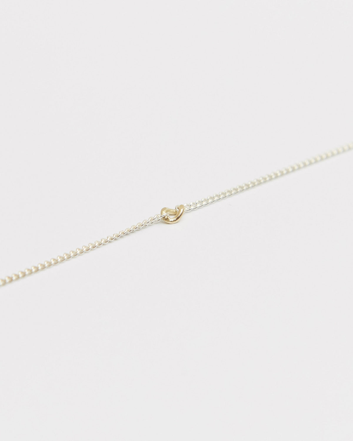 Close-up of the 14K gold detail on a fine sterling silver curb chain – HANNA543 B535 gold note chain