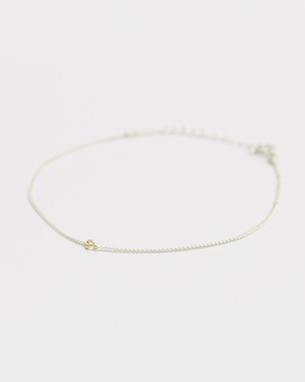 Sterling silver chain bracelet with a small 14K gold accent, laid flat – HANNA543 B535 gold note chain