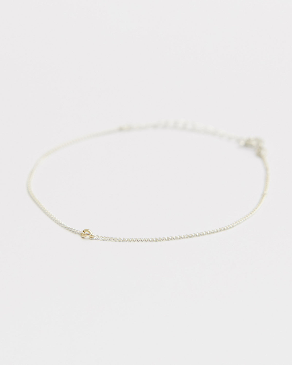 Sterling silver chain bracelet with a small 14K gold accent, laid flat – HANNA543 B535 gold note chain