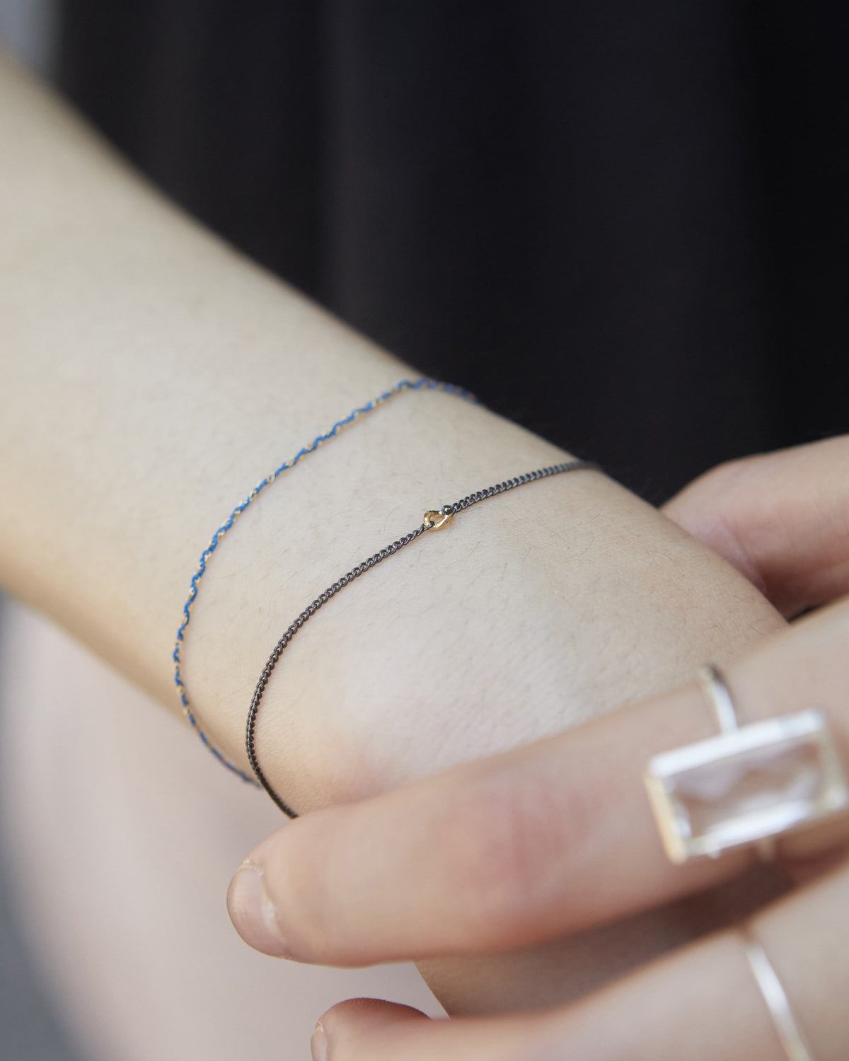 Antique silver and gold chain bracelet layered with a blue cord bracelet on the wrist – HANNA543 B535 gold note chain