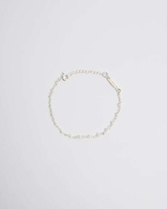 Top view of delicate sterling silver bracelet with tiny pearl details