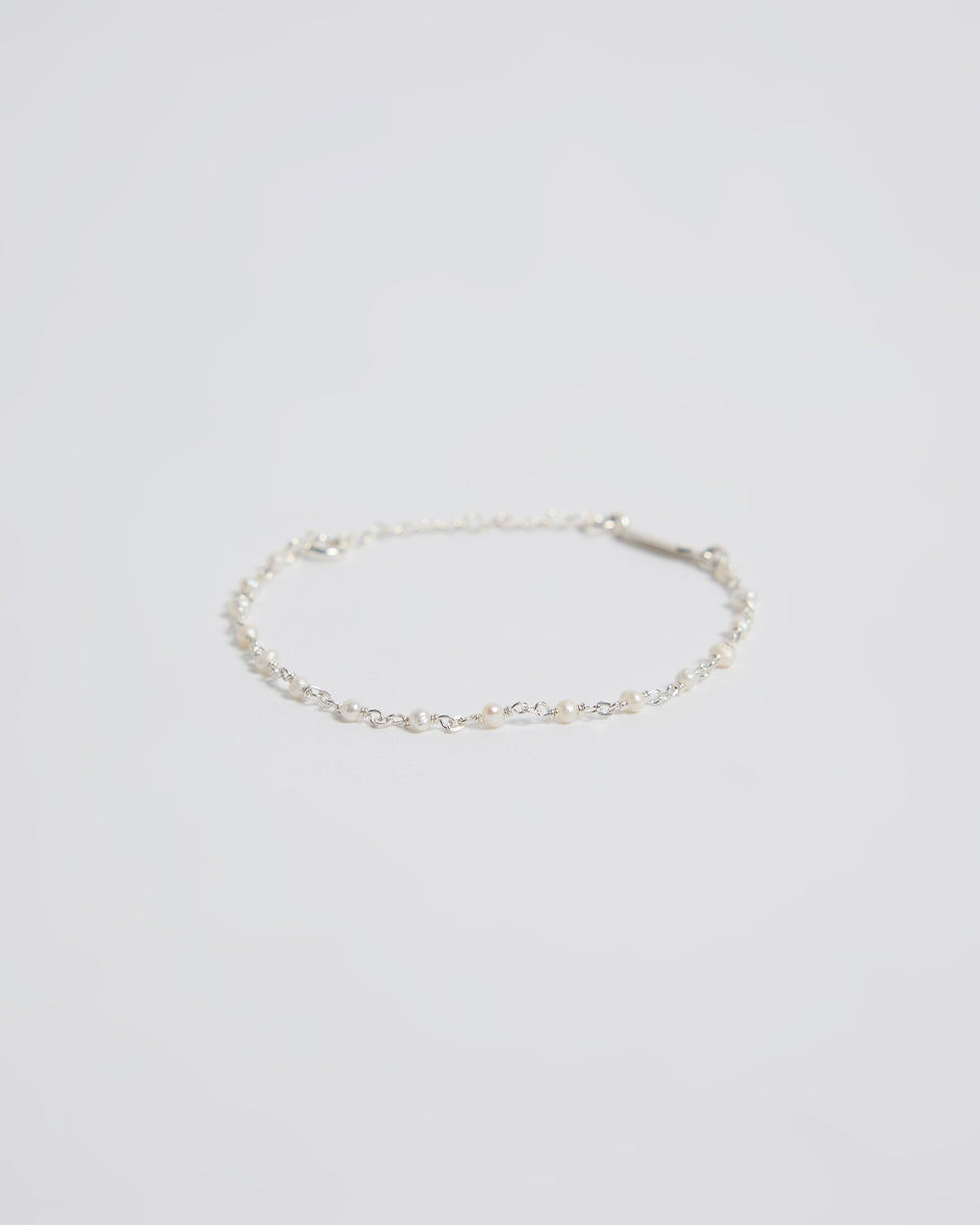 Minimal sterling silver pearl bracelet on white background