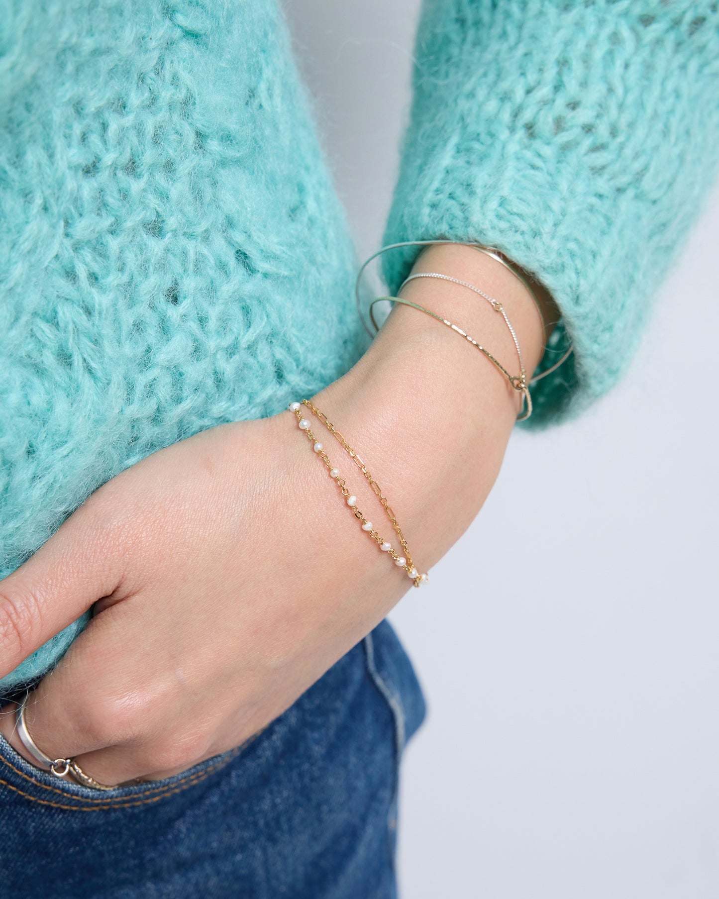 Close-up of layered gold pearl bracelet with tiny pearls, minimalist dainty bracelet for stacking