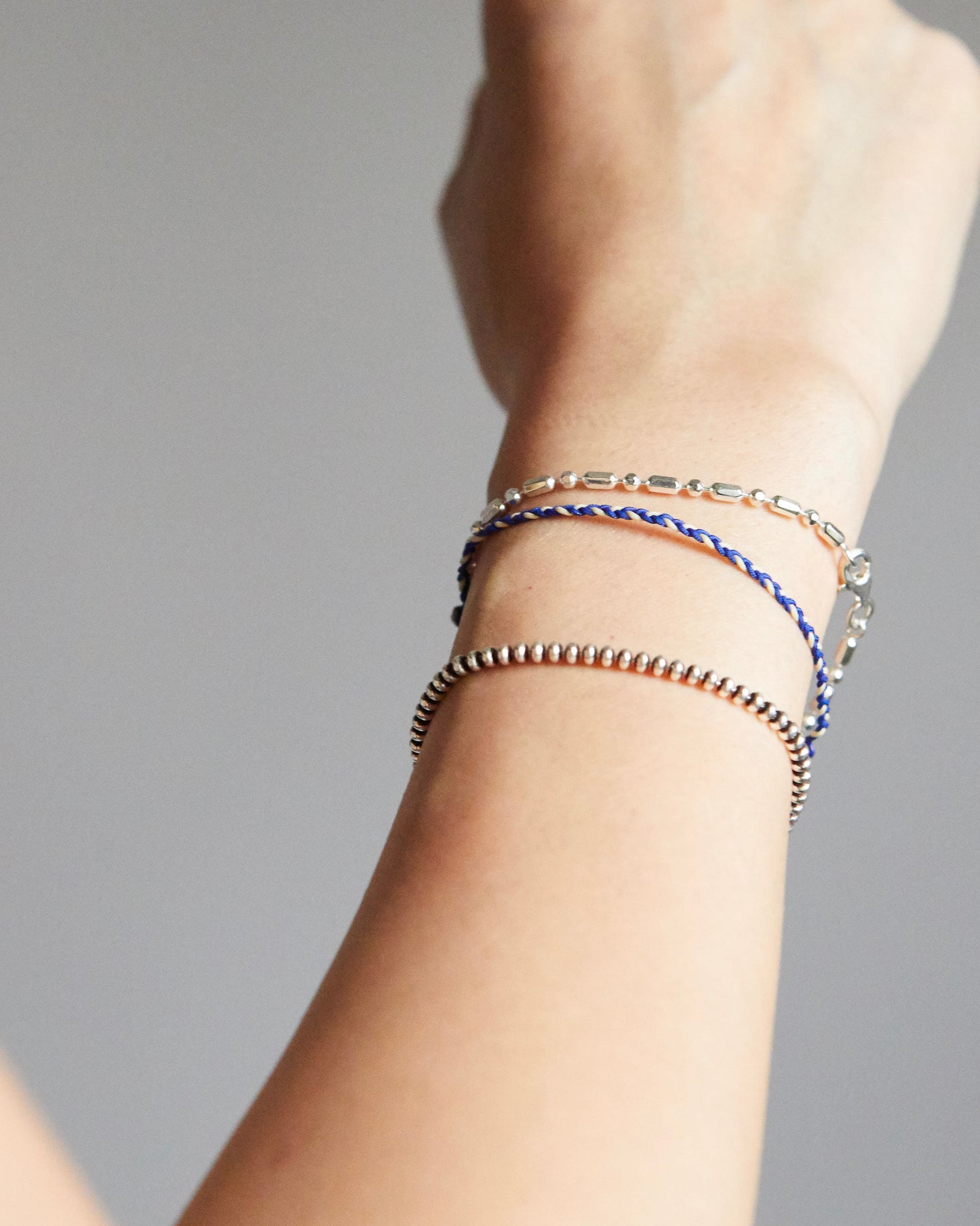minimal silver bracelet with bead and bar pattern, worn close to skin