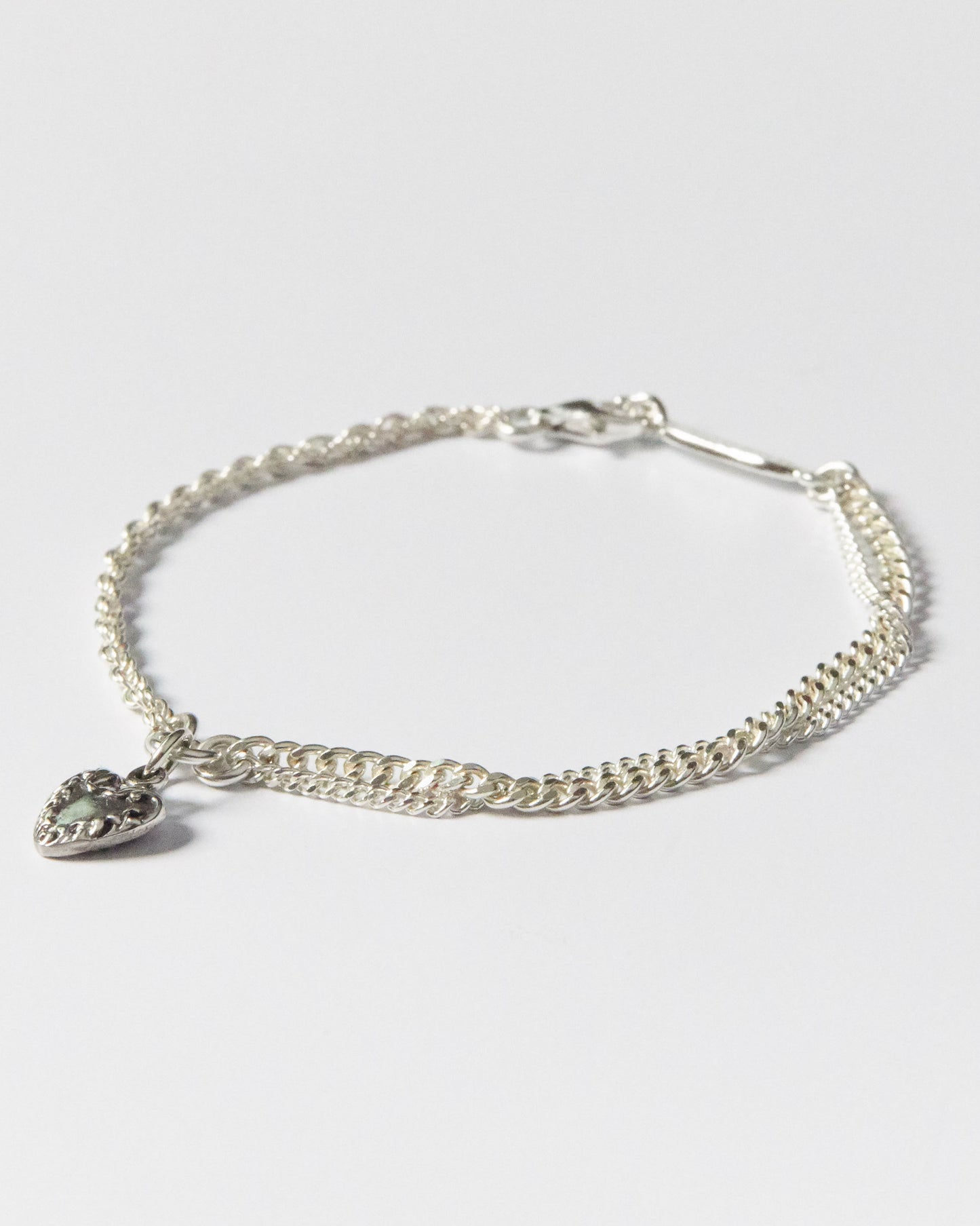925 silver bracelet with double chain and vintage-style heart charm on white background