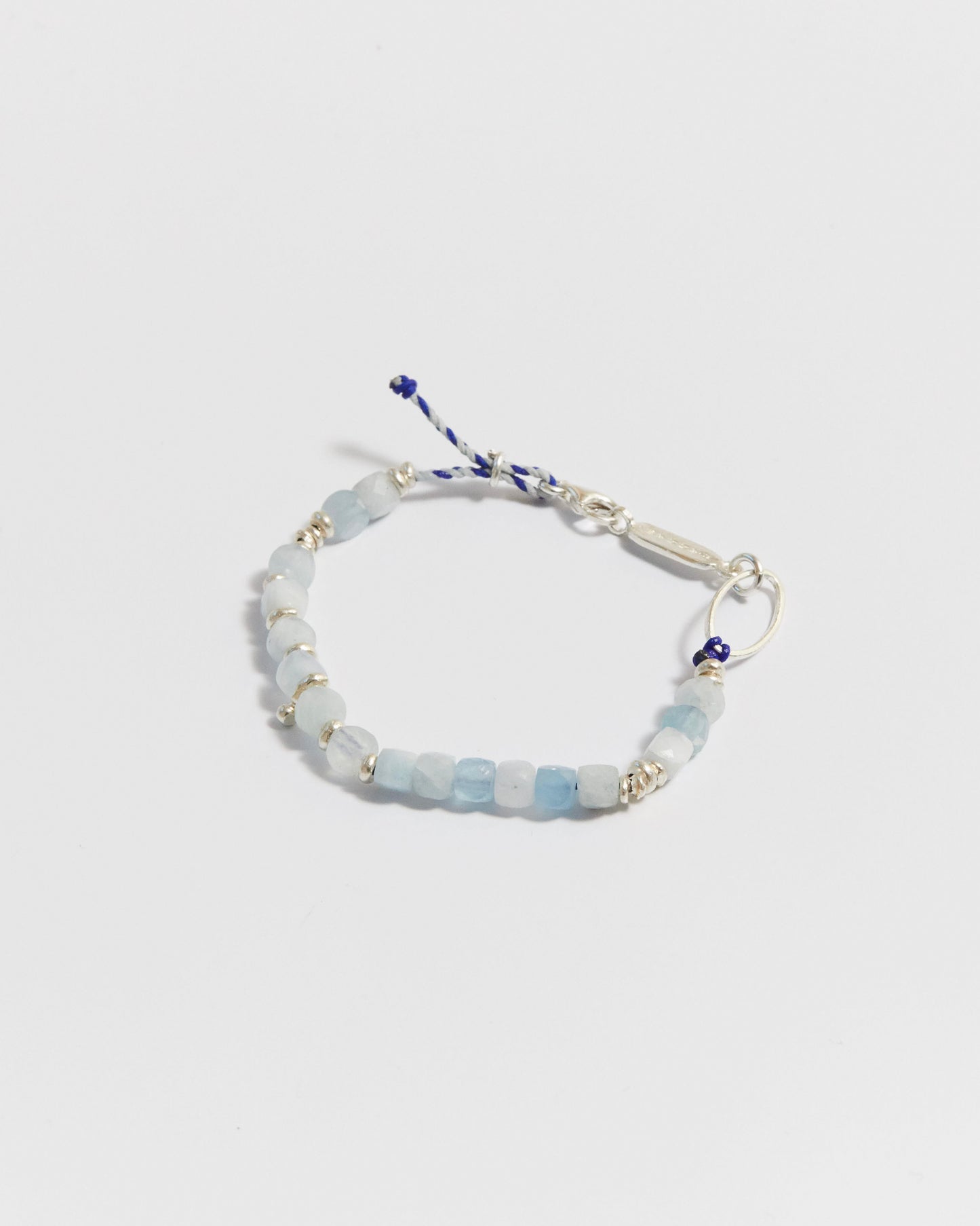Close-up of aquamarine beaded bracelet with silver accents and blue cord