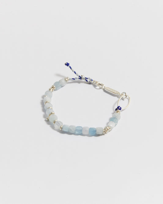 Close-up of aquamarine beaded bracelet with silver accents and blue cord