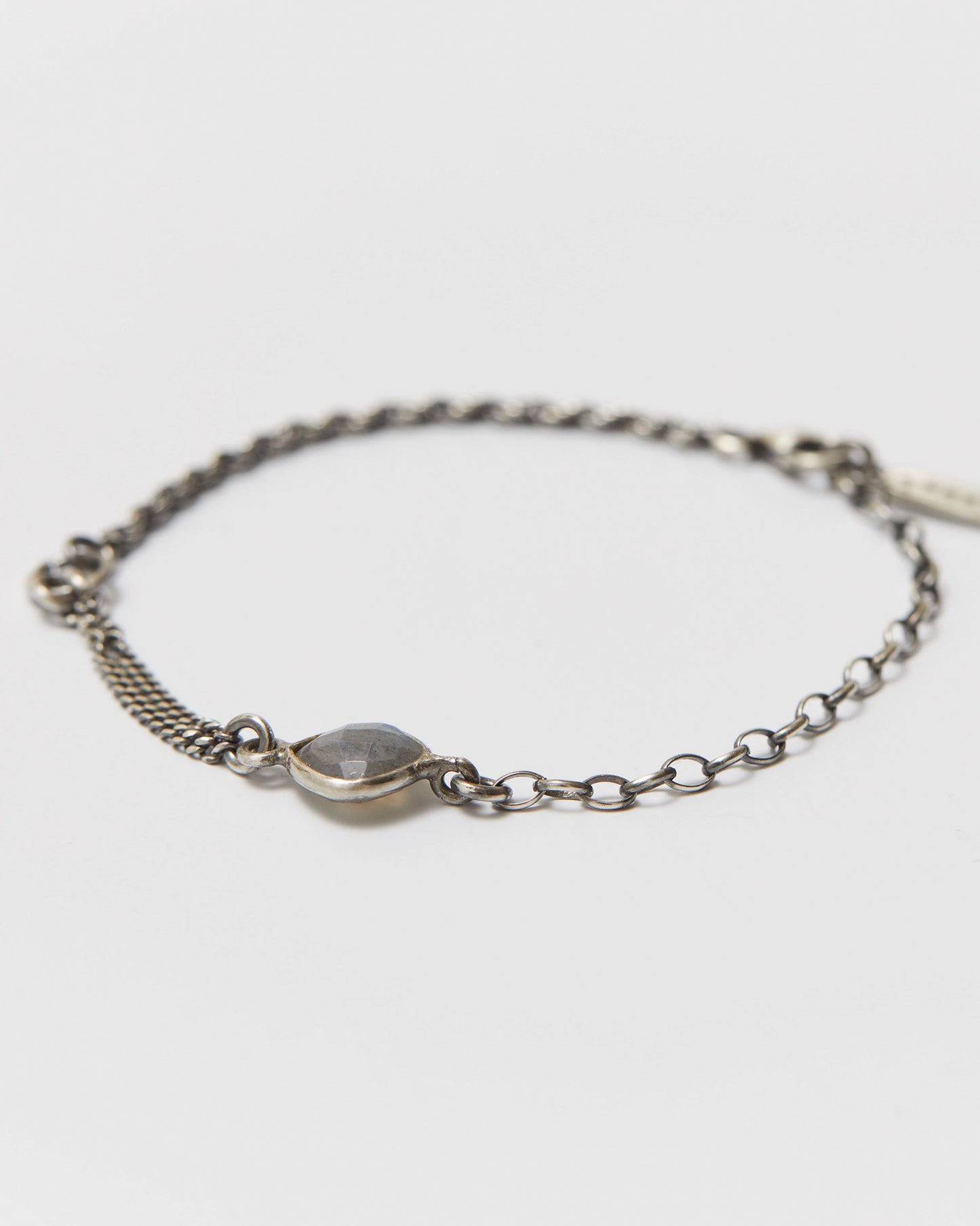 antique Silver bracelet with a small gemstone on a light gray background
